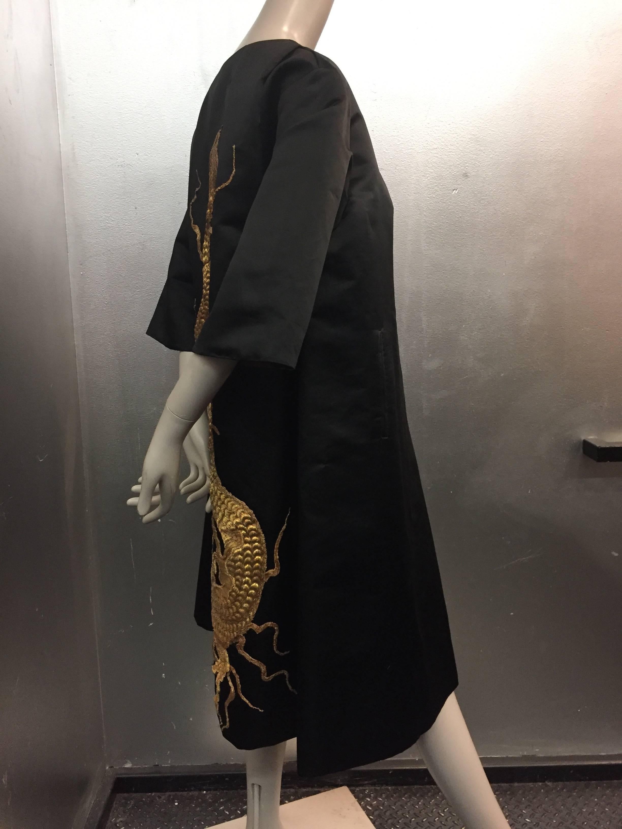1950s Black silk satin evening coat with stunning antique gold Chinese dragon appliqué.  Lined in tobacco brown silk gazar for structure. Watteau back and 3/4 length sleeves. Side pockets. Dragon appliqué is most likely of a 1920s vintage. 
