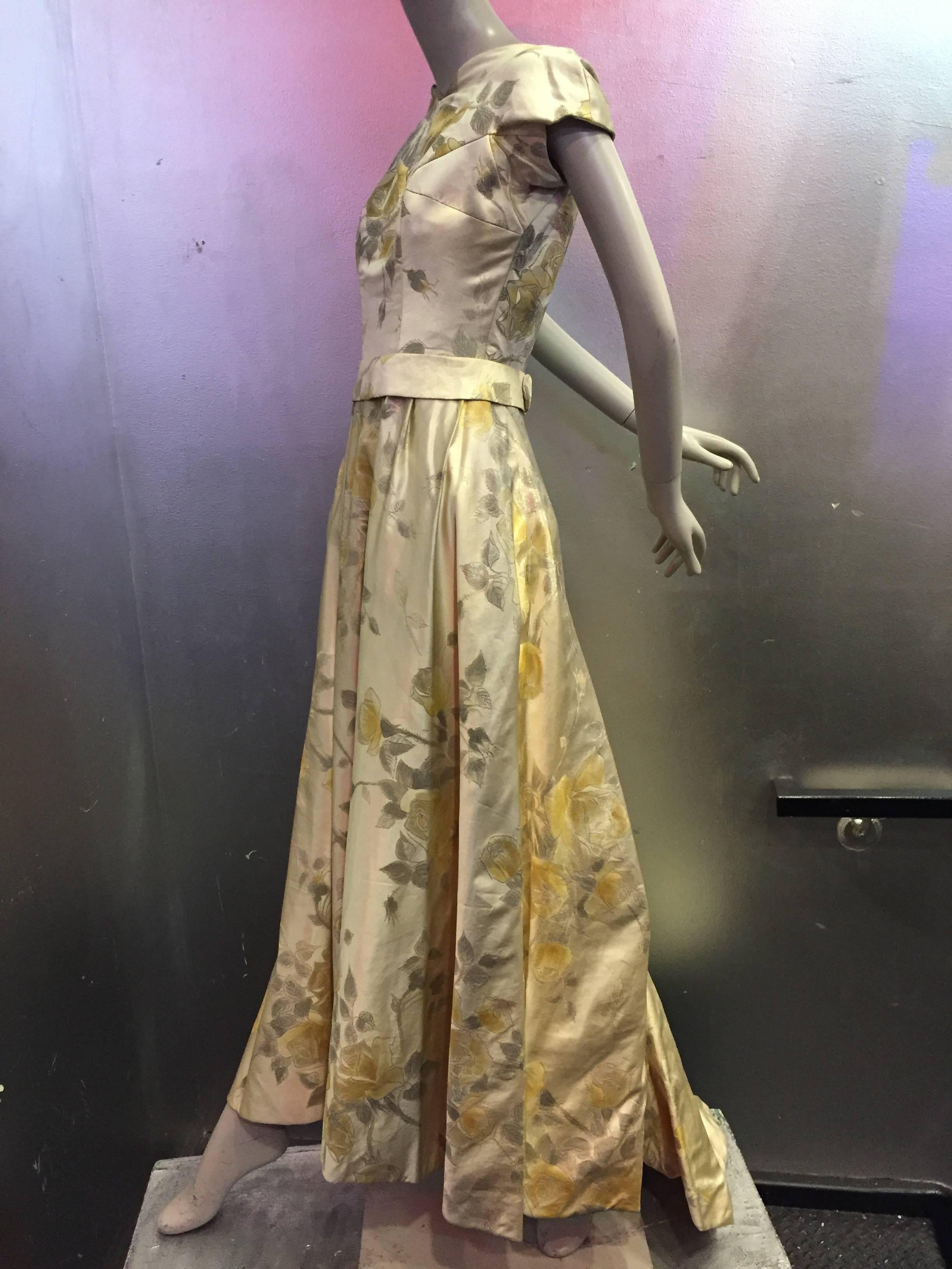 An exceptional, museum-worthy 1950s James Galanos golden silk and lamé brocade gown in a rose pattern:  Molded cap sleeves and extremely low dipping back. Back of gown and train are exquisitely detailed with button-down placket on back of skirt and