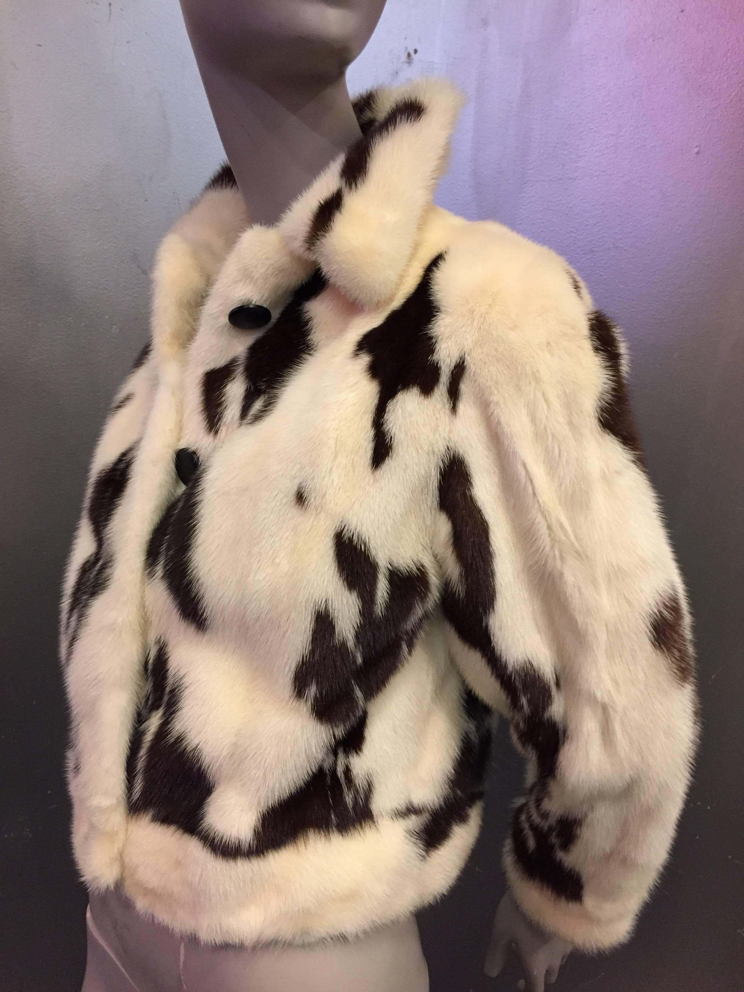 A sporty and chic 1970s Neiman Marcus spotted mink cropped jacket in brown and white.  Buttons up the front as well as at cuffs.  Fully lined in black silk with a banded waist. 