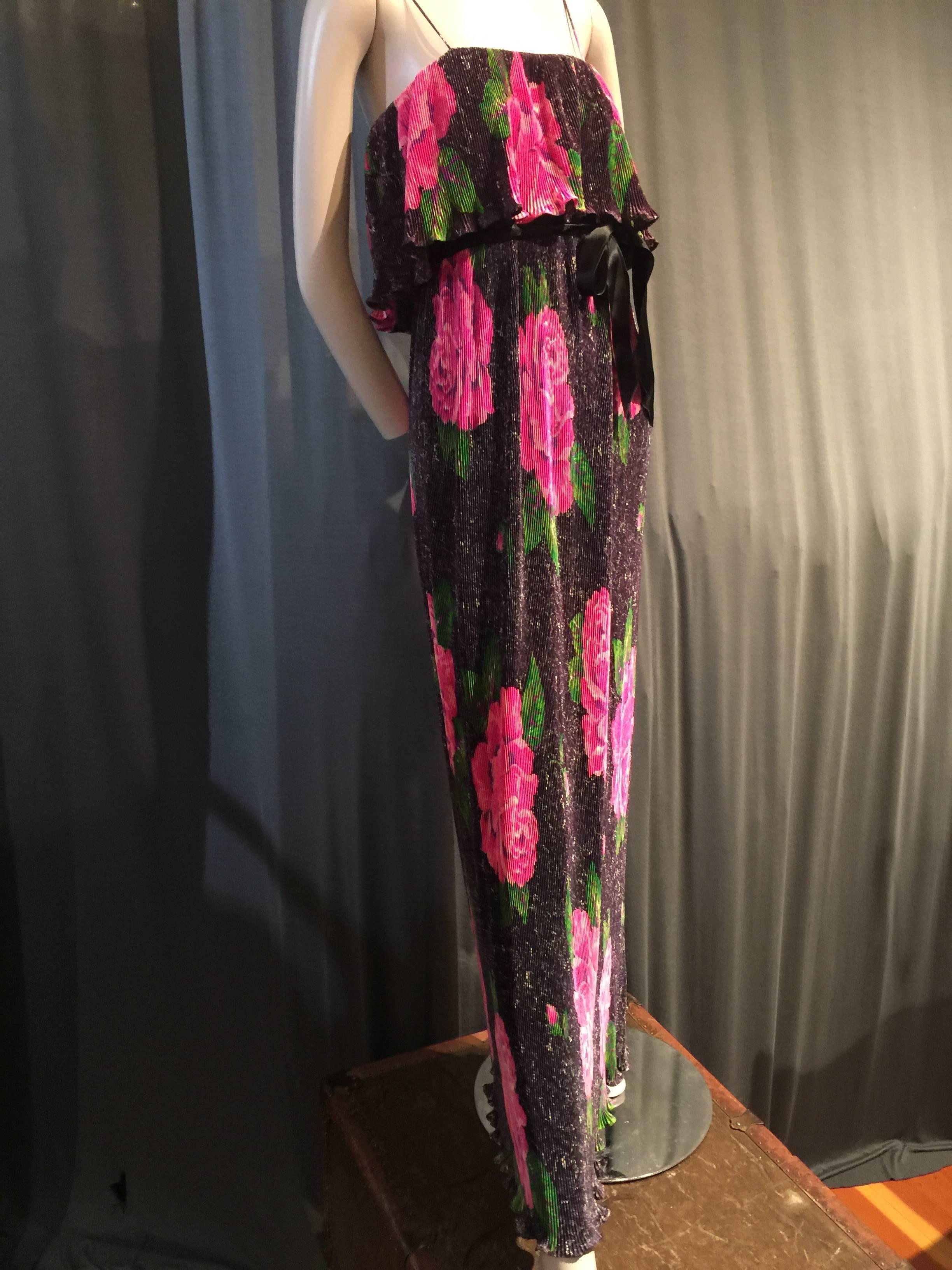 A lovely 1970s Bonwit Teller accordion pleated maxi gown in a sleek synthetic with a pixelated rose print. Spaghetti straps with a short tier of ruffle on bodice and a velvet sash at waist.