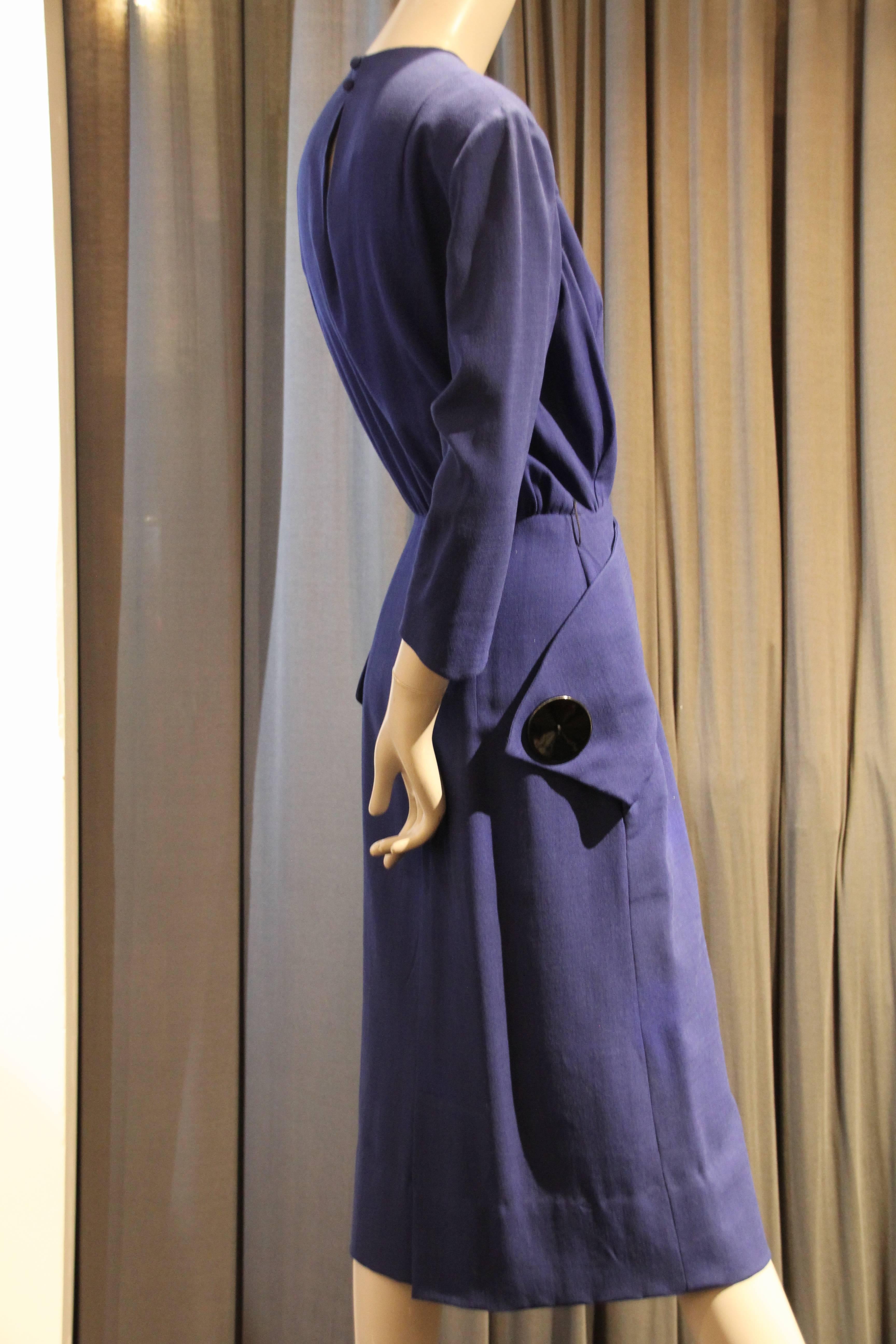 A wonderful late 1940s Eisenberg indigo blue lightweight wool tailored dress w beautiful detailing and charming large button trimmed tabs at neckline and hips. 