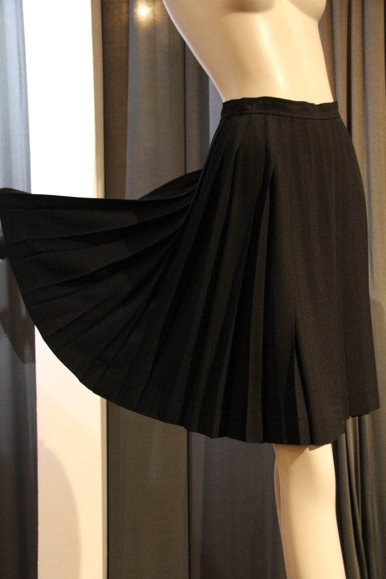 A Saint Laurent black rayon crepe pleated knee-length unlined skirt. Side Zipper closure. 