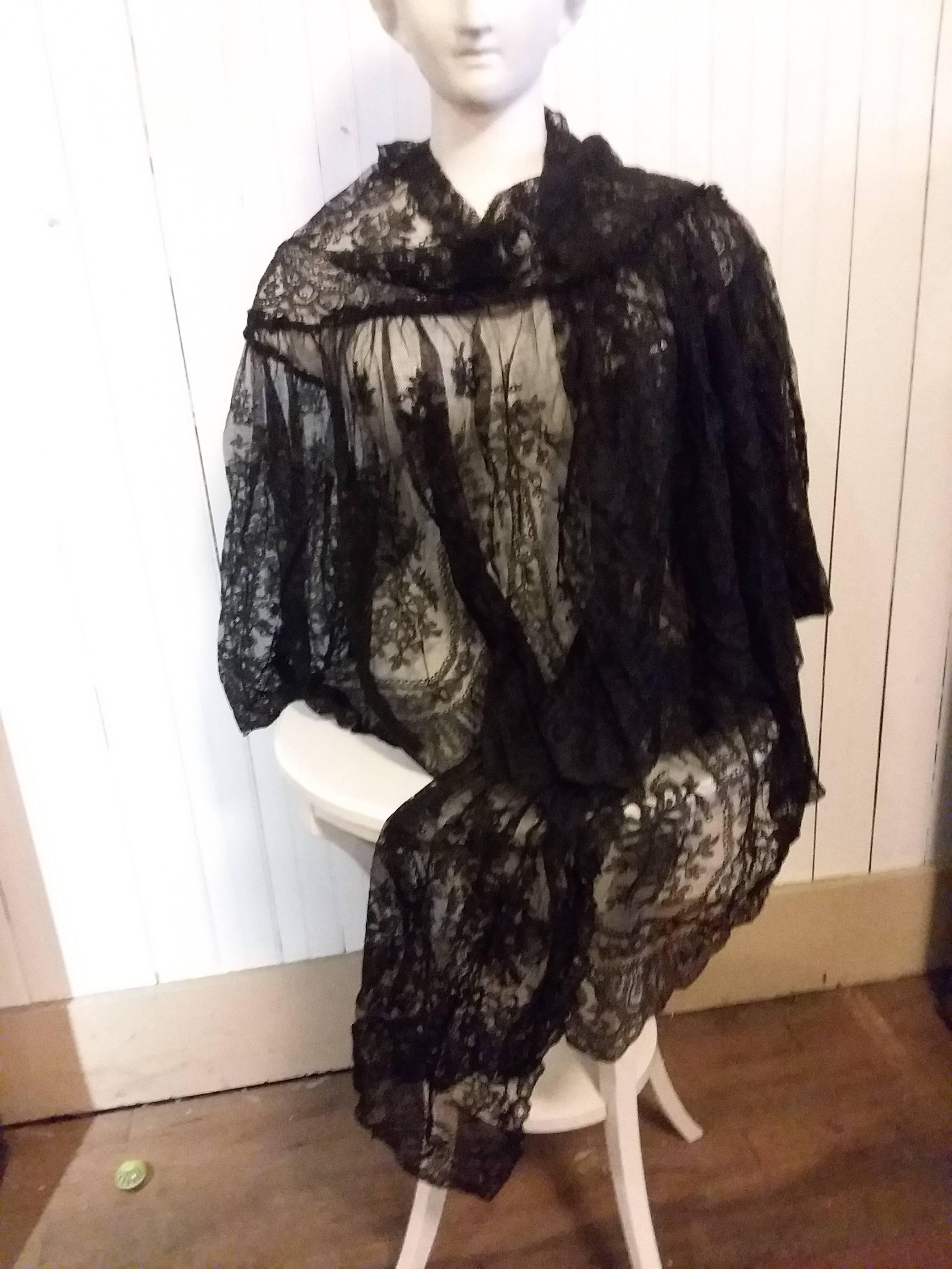 A beautiful black Victorian silk Chantilly lace shawl with a flat triangular top piece and a gathered ruffle tier.  A stunning piece in very good condition., A few small gaps in tulle, but not noticable.