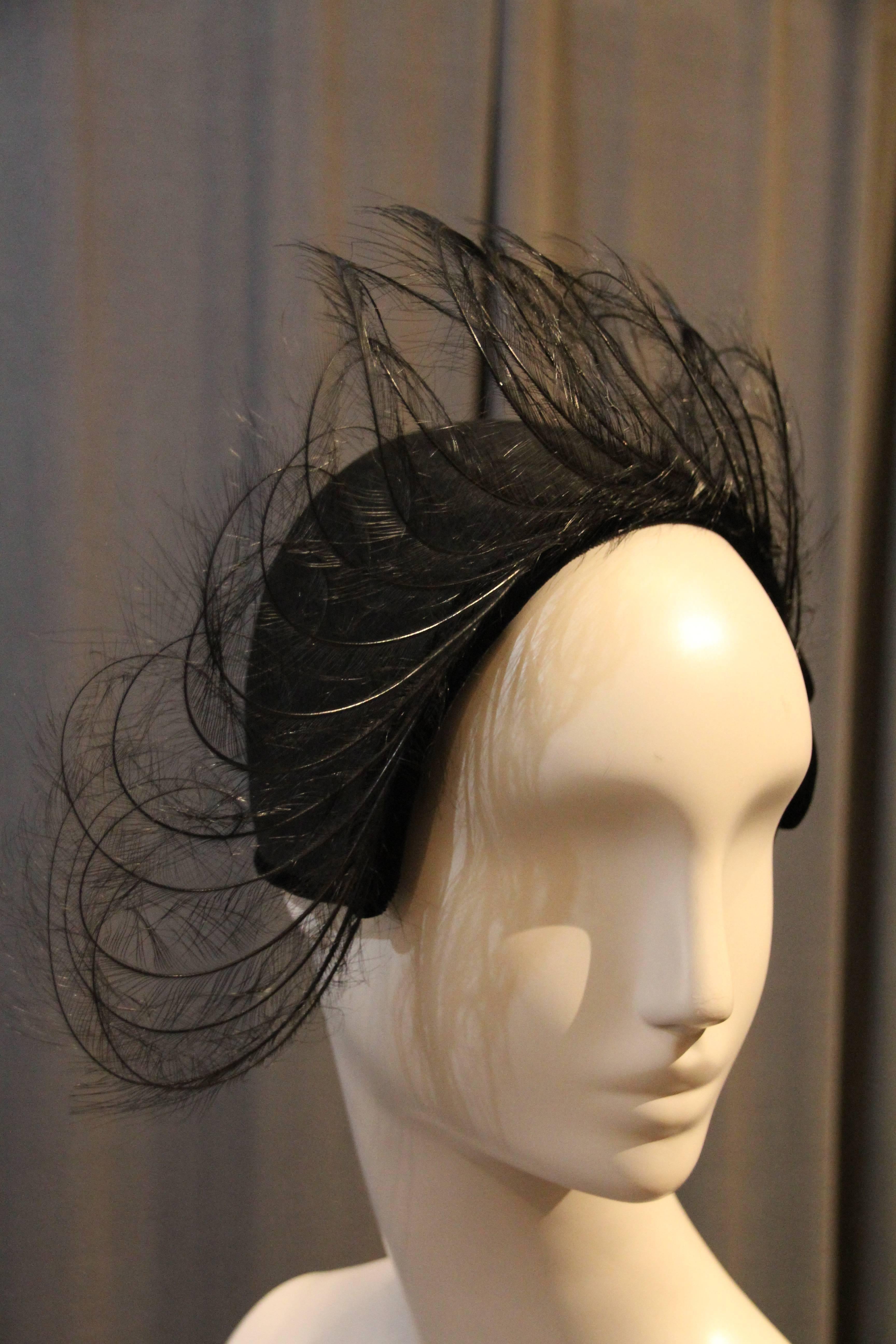 An incredible 1950s Elsa Schiaparelli cashmere felt cloche or skull cap style hat: A sophisticated, face-framing style with felt bow at left side and a stunning fan of curled egret feathers. 1920s-inspired. 