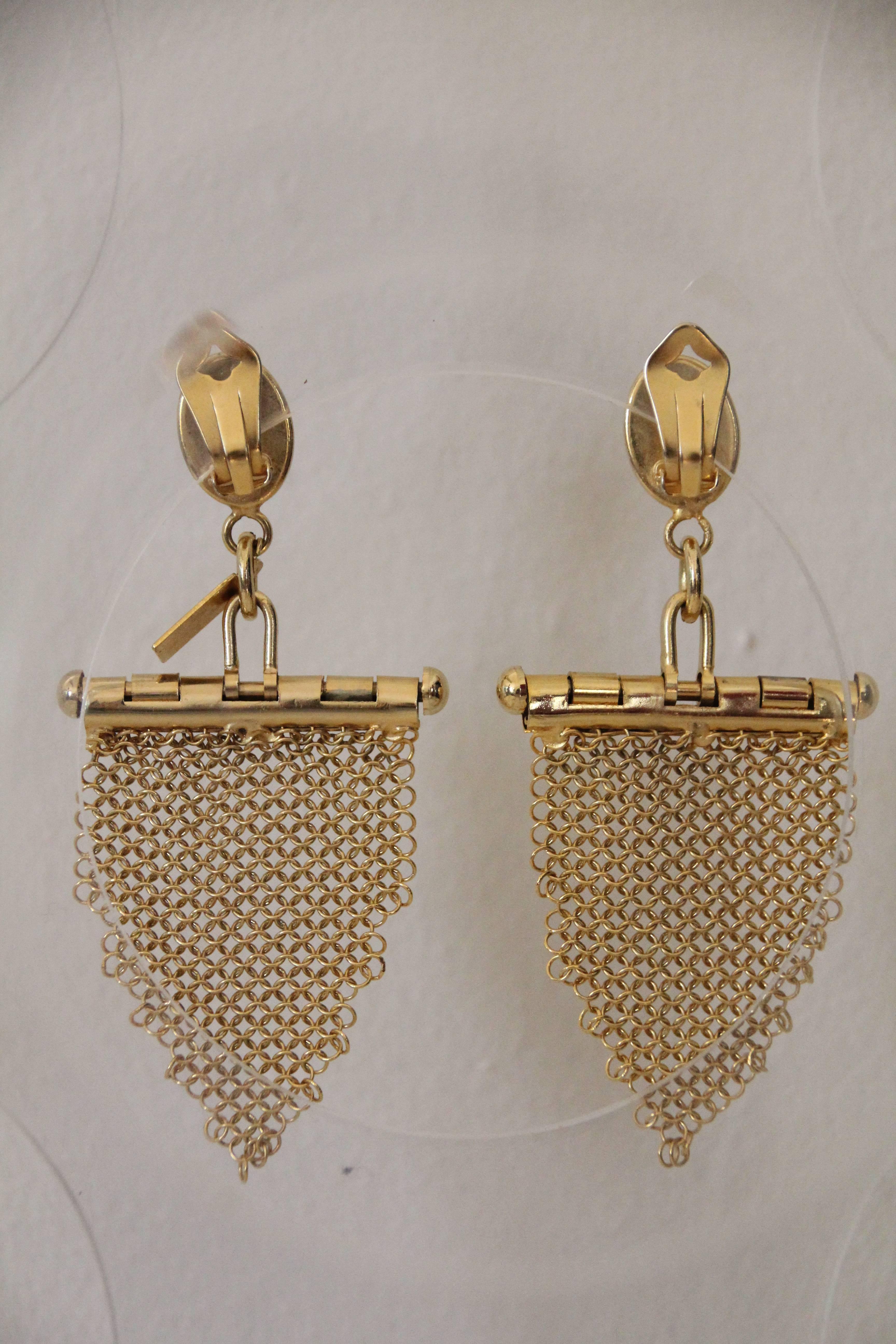 1980s U. Correani gold-tone chain mail fringe chandelier earrings. Dangling fringe is attached to a nicely designed hinged bar for lots of movement. Clip is topped with a carnelian-color glass cabochon. These gorgeous clip-ons are a dramatic 4