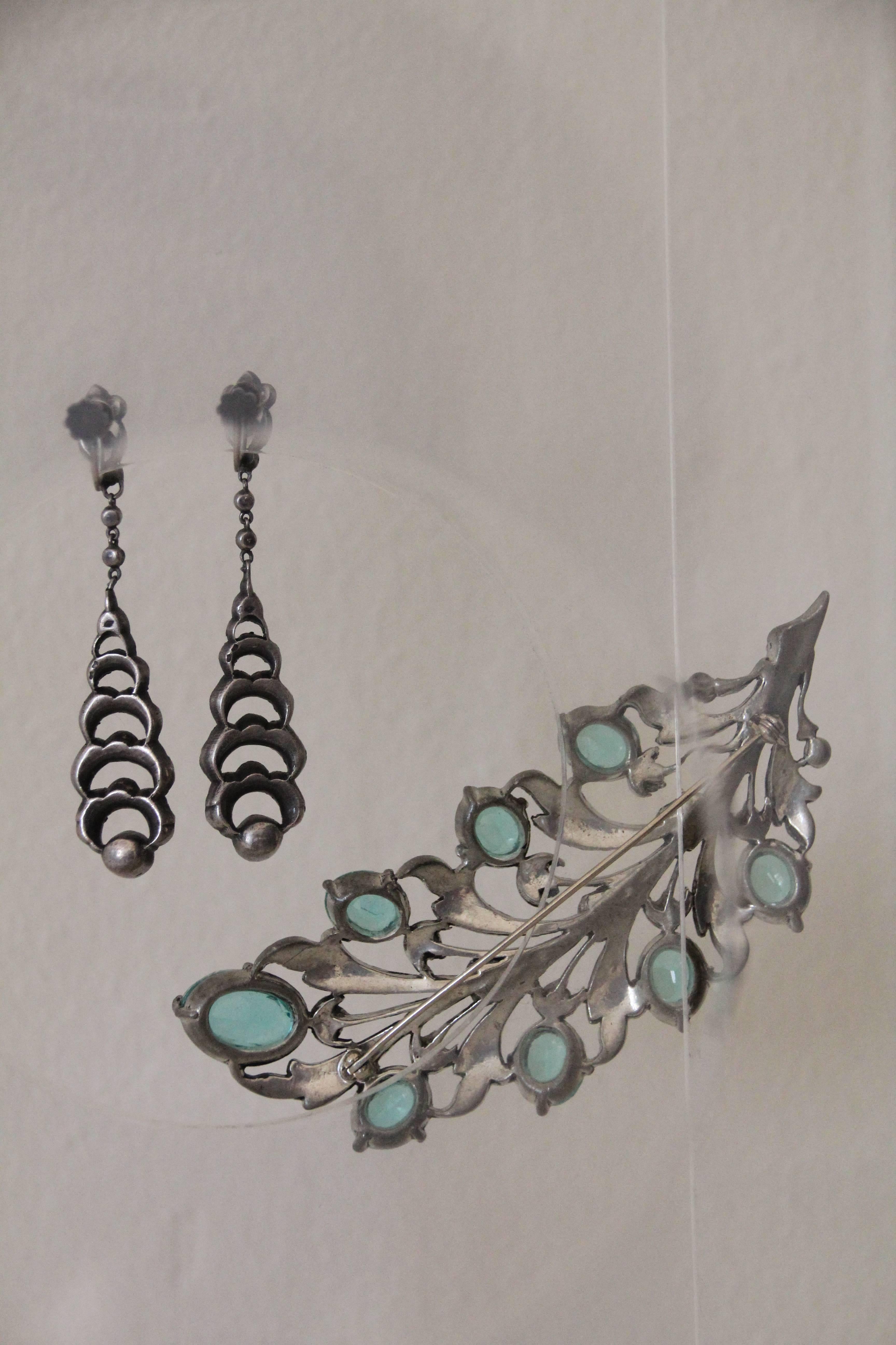 A gorgeous 1930s brooch and earring set: Aquamarine-toned and clear rhinestone leaf or feather brooch with japanned settings, come with matching pair of teardrop shape rhinestone dangle earrings.  Brooch is 4