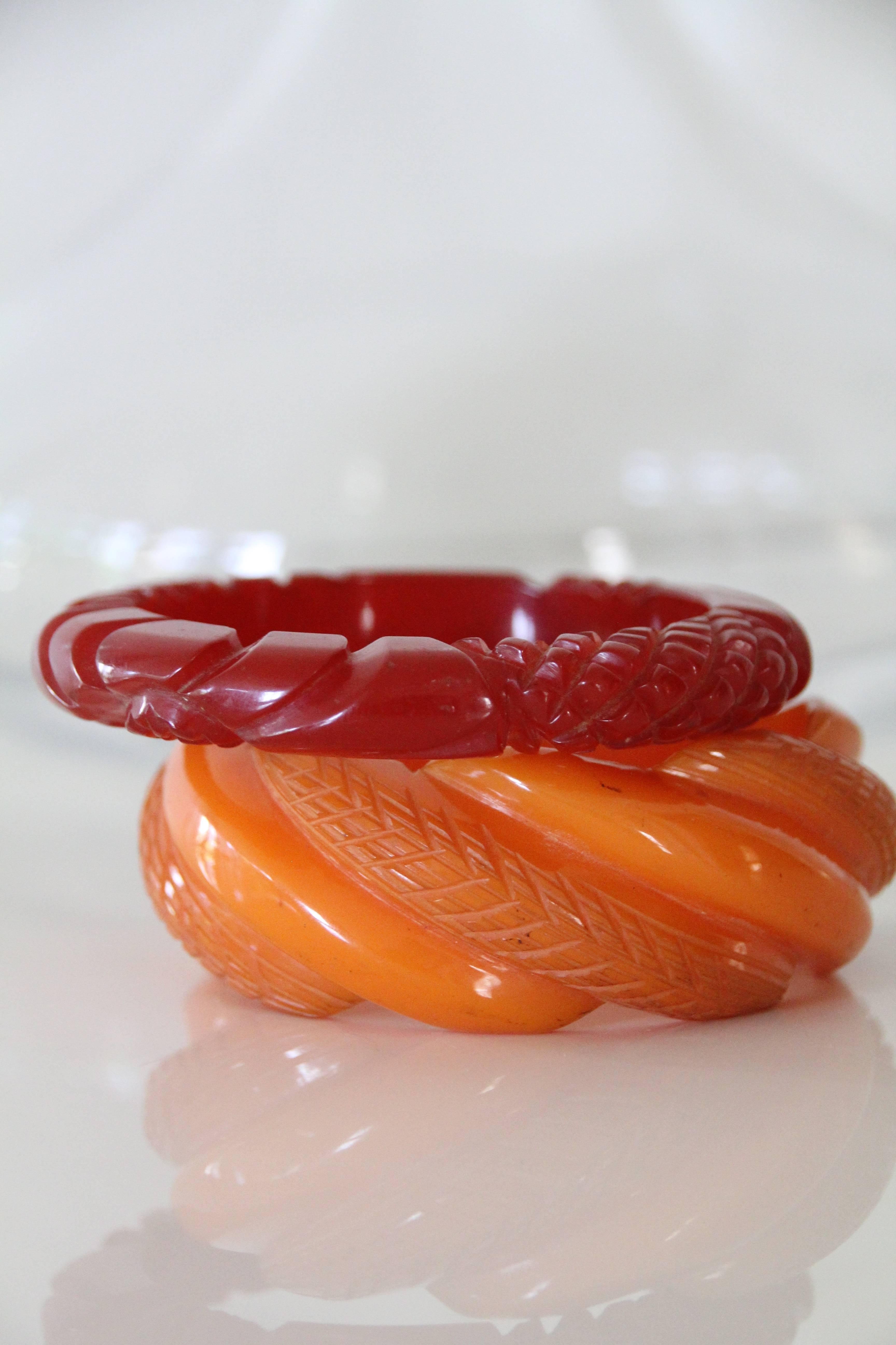 A beautiful and complimentary lot of 2,1940s, heavily carved, butterscotch and cinnabar colored, Bakelite bangles. We love that delightful and distinctive look of stacked Bakelite bangles!! 