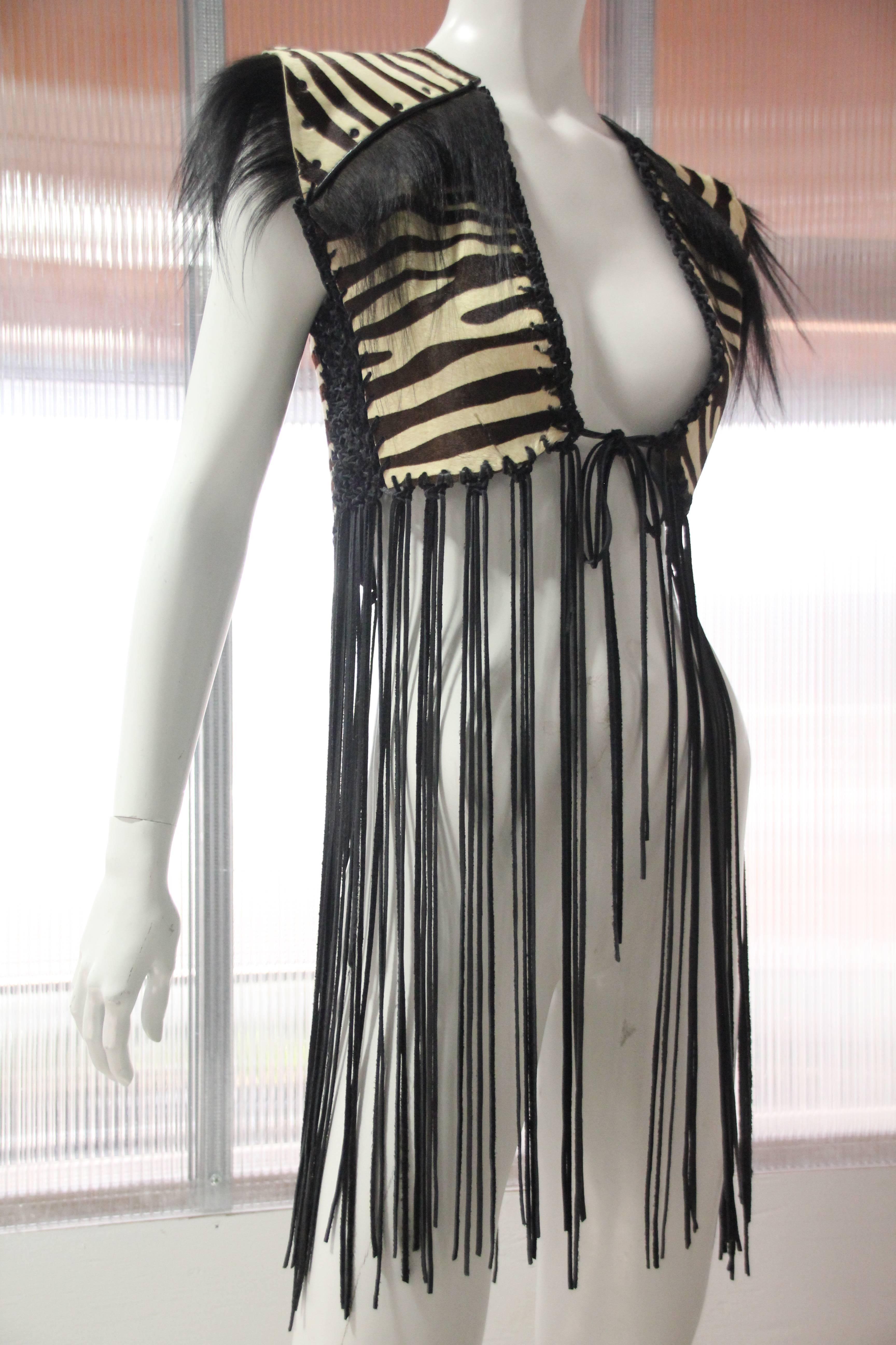 1970s-Style custom-made zebra-stenciled calf skin vest w leather cord fringe, leather macrame insets, metal studs and monkey fur trim. Wow! 