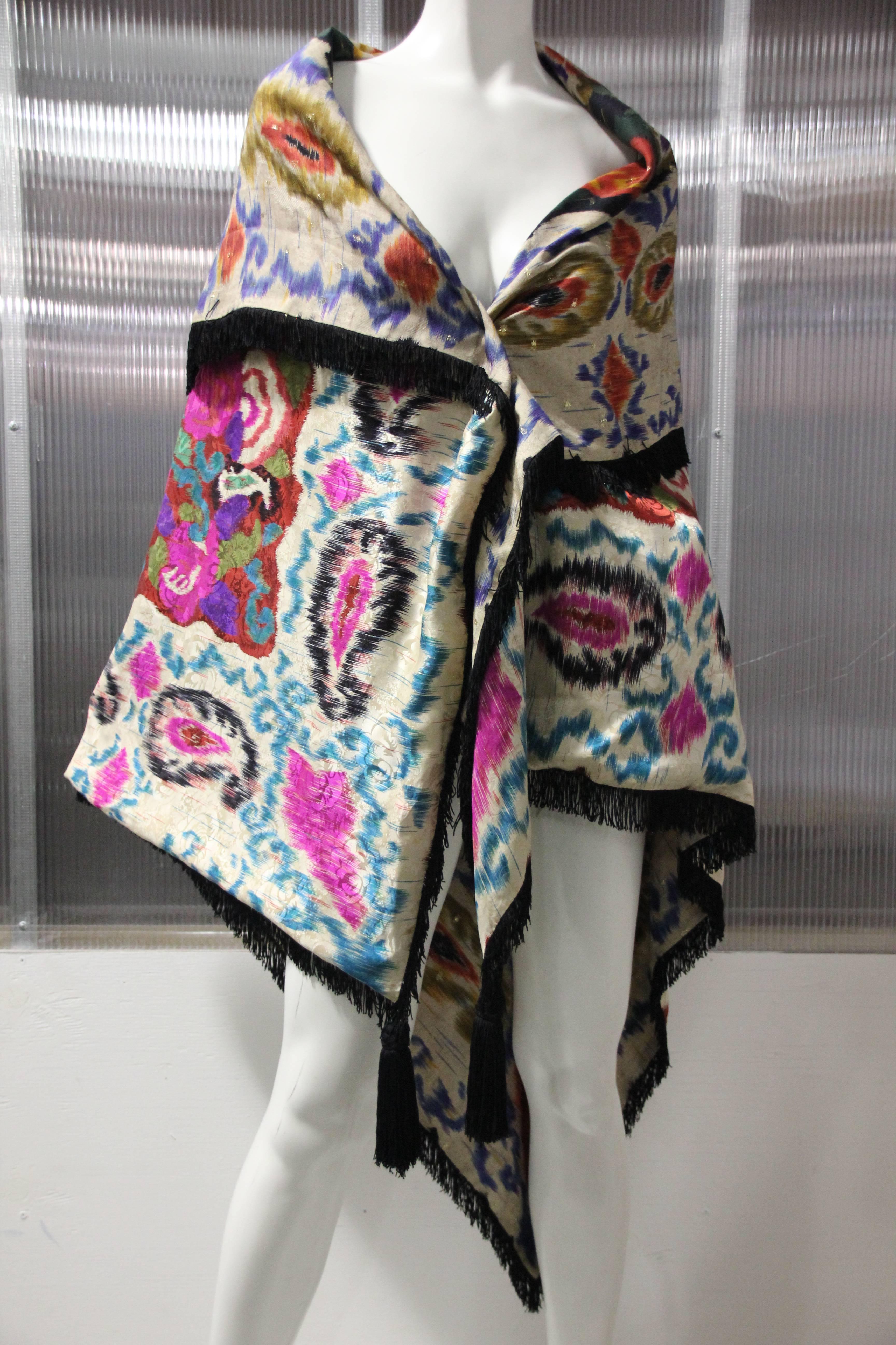 1980's Ungaro of Paris made in Italy silk paisley and floral pattern double-sided large shawl is trimmed in black rayon fringe with large tassels at front points.
This stunning and vibrant large silk shawl can be worn in many ways and can be folded