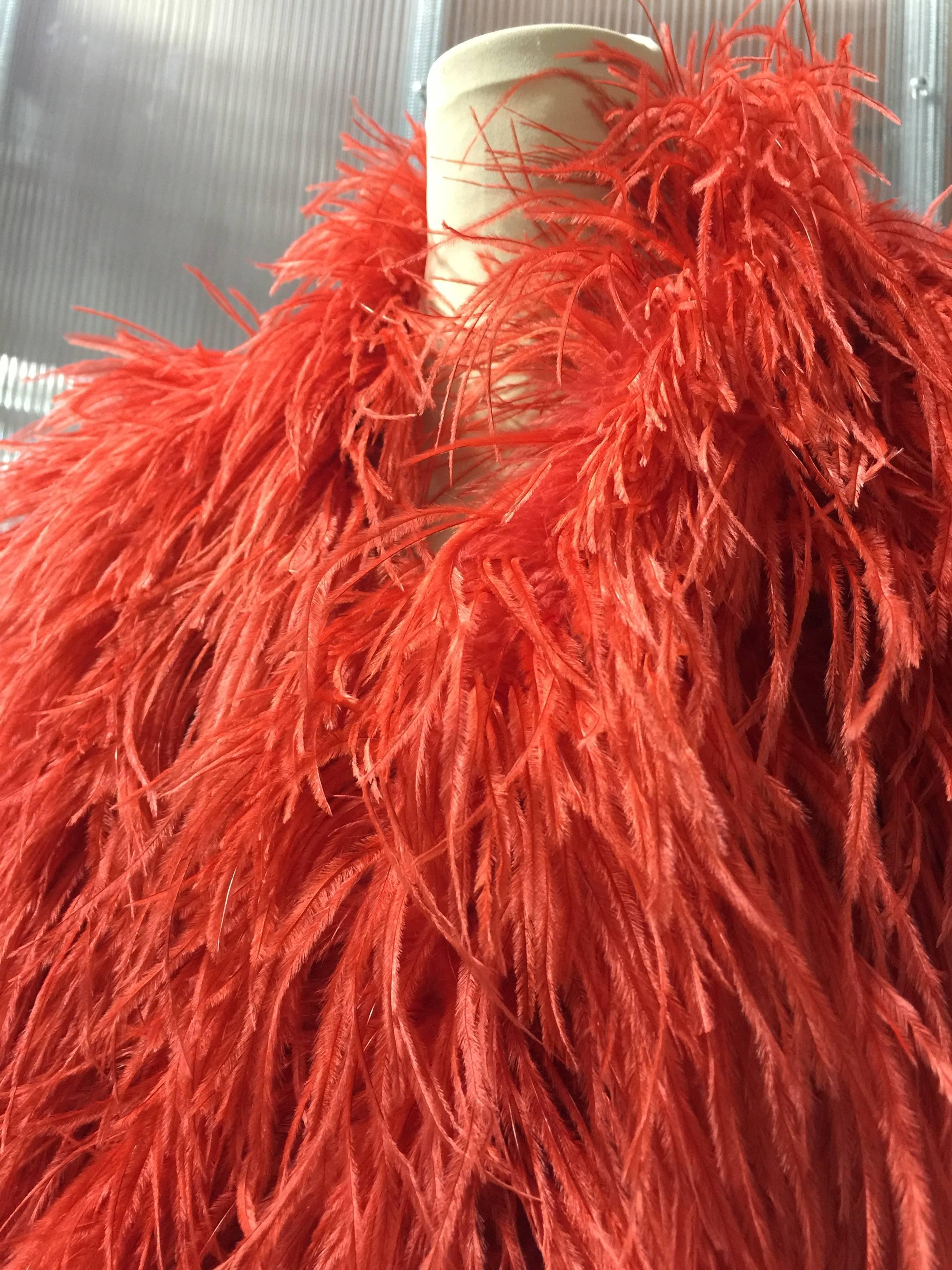 1980s Adrianne Landau vibrant coral red ostrich feather chubby with coordinating satin lining.  Covered hook and eye closures at front. Fits US size Small. 