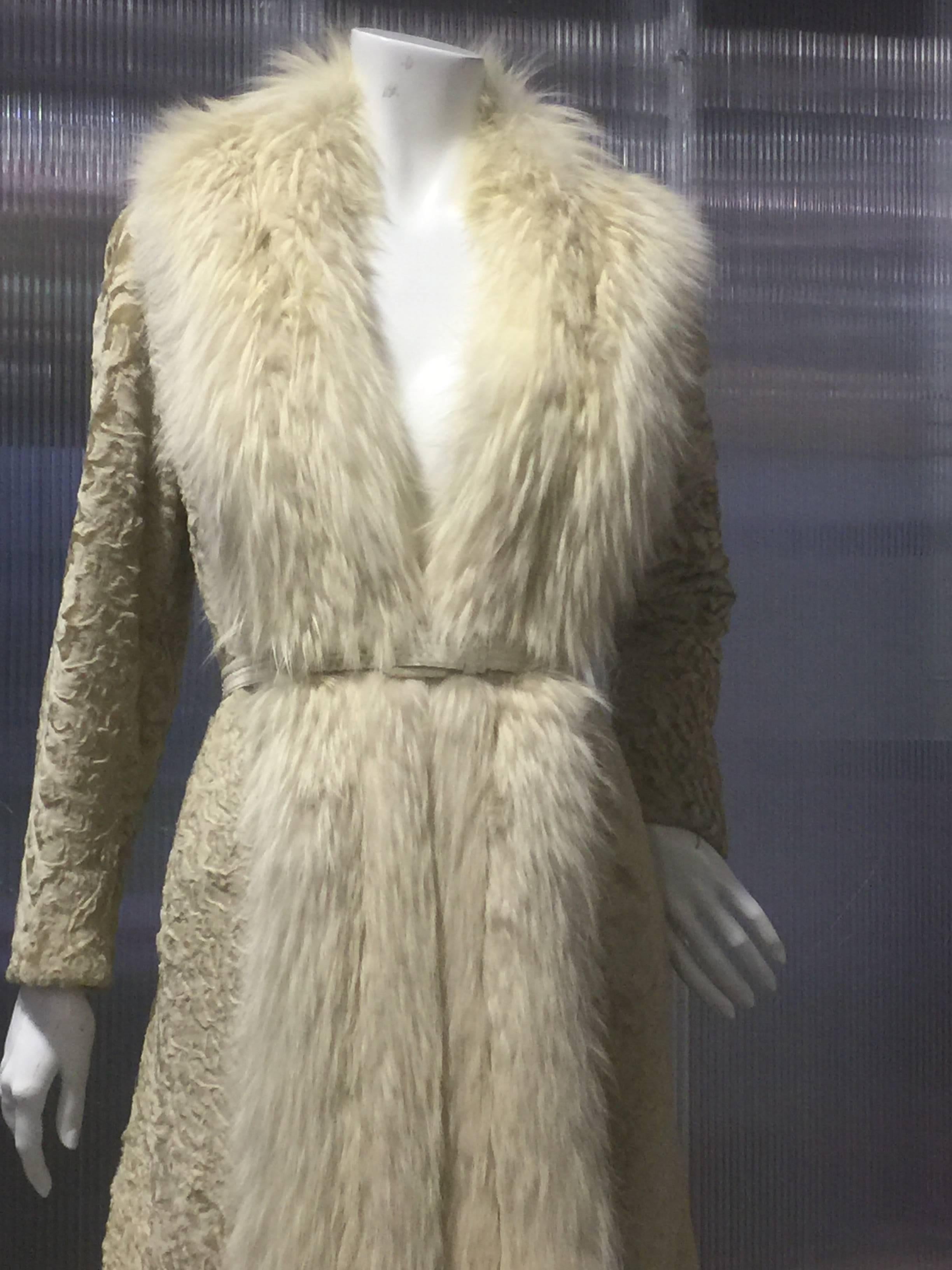 This elegant 1970's blonde-colored Broadtail Persian lamb coat is lean cut thru the shoulders and features a nice full semi-swing back. Nice calf-length cut with tapered sleeves , side slit pockets and extravagant and lush fox fur trim to the hem