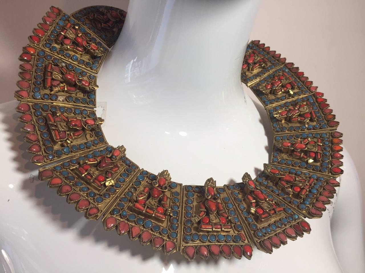 A stunning jointed and hinged antique ethnic bib collar necklace w/ coral and glass inset stones and figures.  Hook closure and base metal with gold plating.