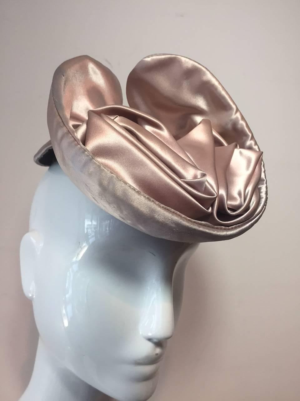 A charming champagne silk satin tilt hat with satin whorls and partial cap.  Fabulous!