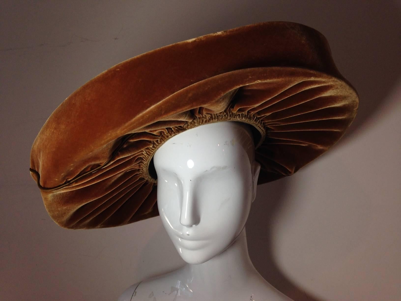 A stunning and unique 1940s Leslie James tobacco brown silk velvet structured and wired cartwheel hat with beautiful lush gathering at crown, top and bottom.  Attaches with combs to sit at a jaunty angle. Measures 17 inches across!