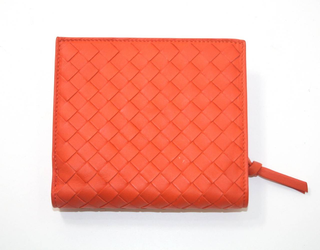 Bottega Veneta’s Orange Nappa Leather Bi Fold Wallet is in pristine condition other than a tiny white spot on the rear.  Please see photos.   Brilliantly designed, this compact wallet is equipped with plenty of slots for currency, coins and cards.