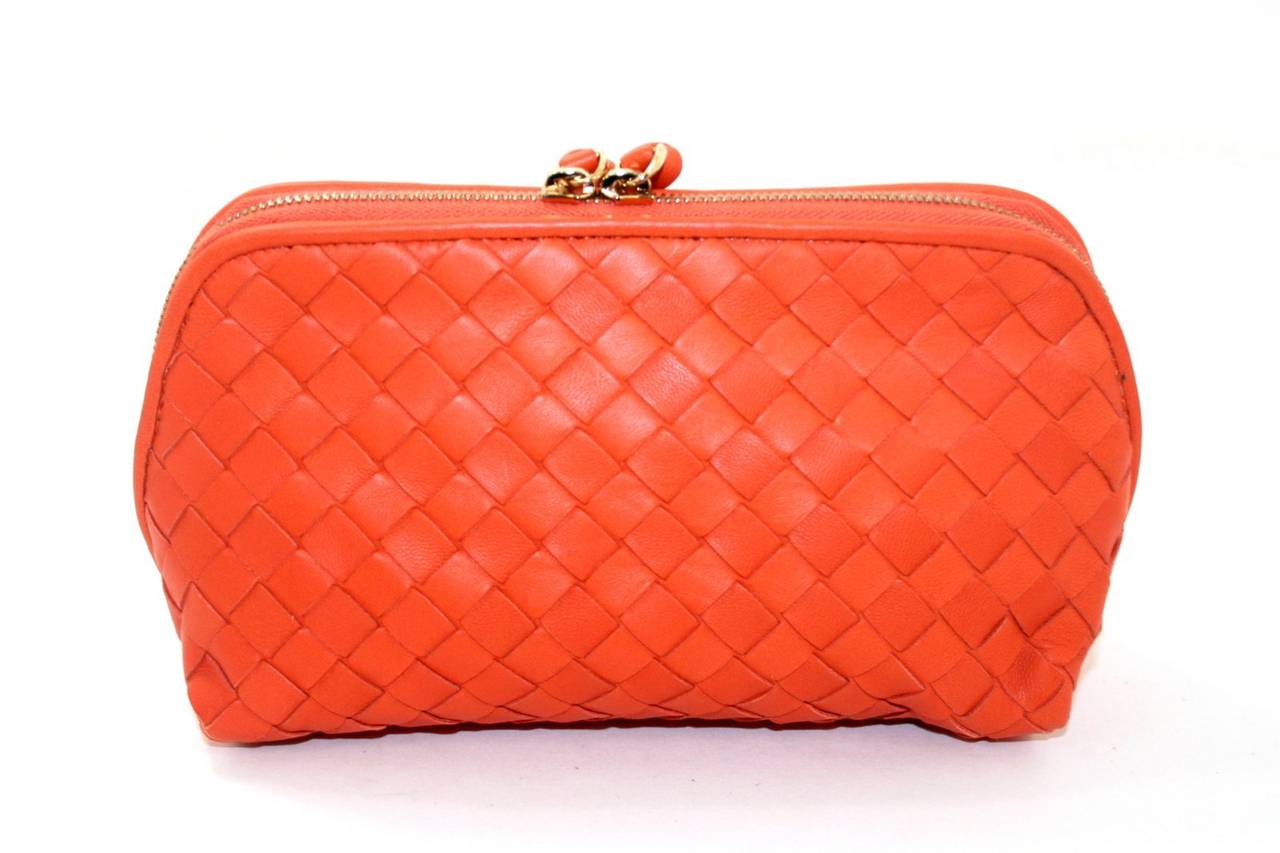 This Bottega Veneta Orange Leather Cosmetic Case is a great piece in pristine condition.   Pretty enough to stand on its own as a clutch, it is easily tossed inside a larger bag and holds cosmetics with style. Current retail is $580.00.

 Vibrant