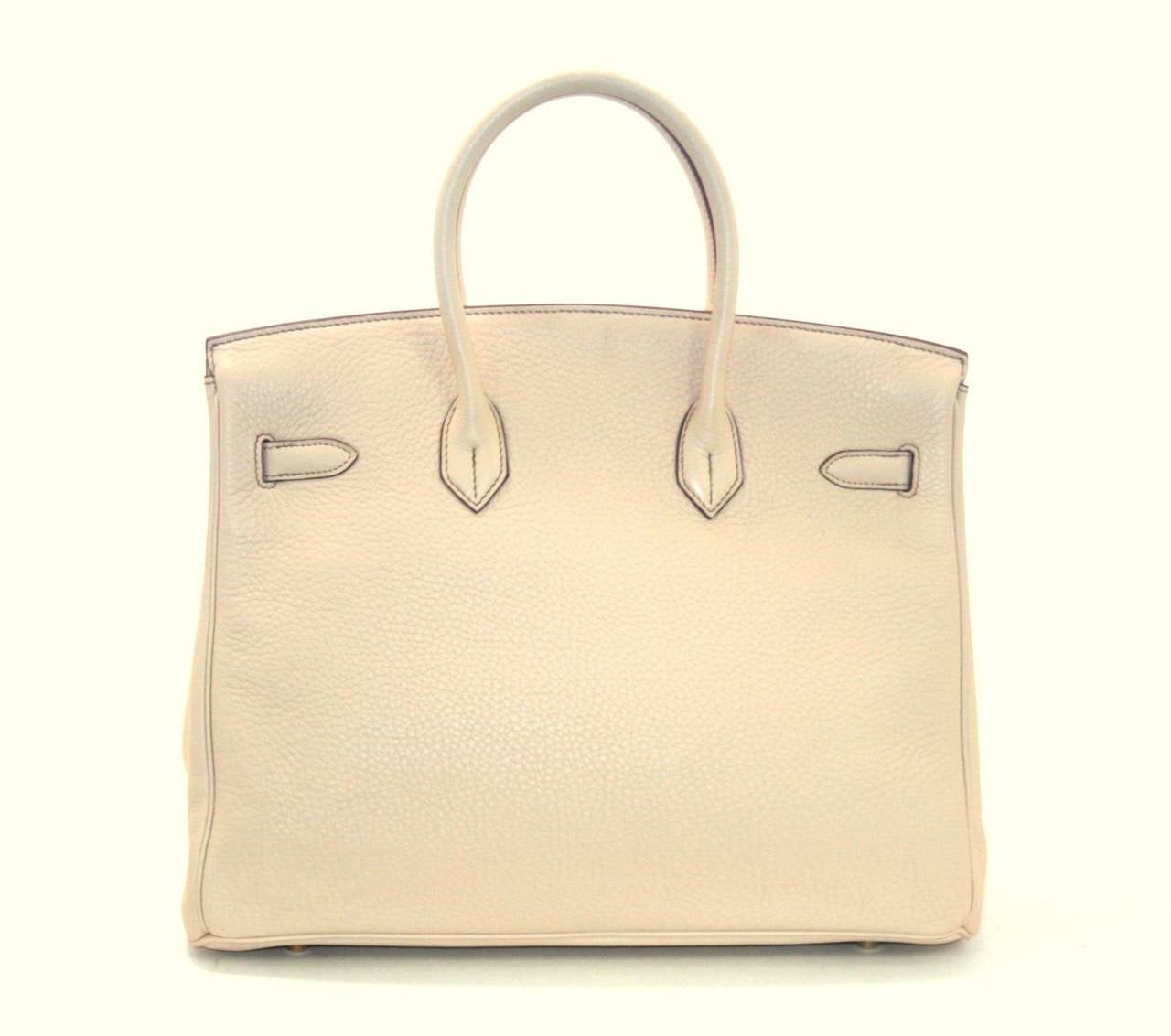 Hermes Beige Clemence Birkin in 35 cm size; nearly pristine.  Protective plastic remains intact on all hardware except the feet and toggle; carried perhaps one time.     Crafted by hand and considered by many as the epitome of luxury items, Birkins