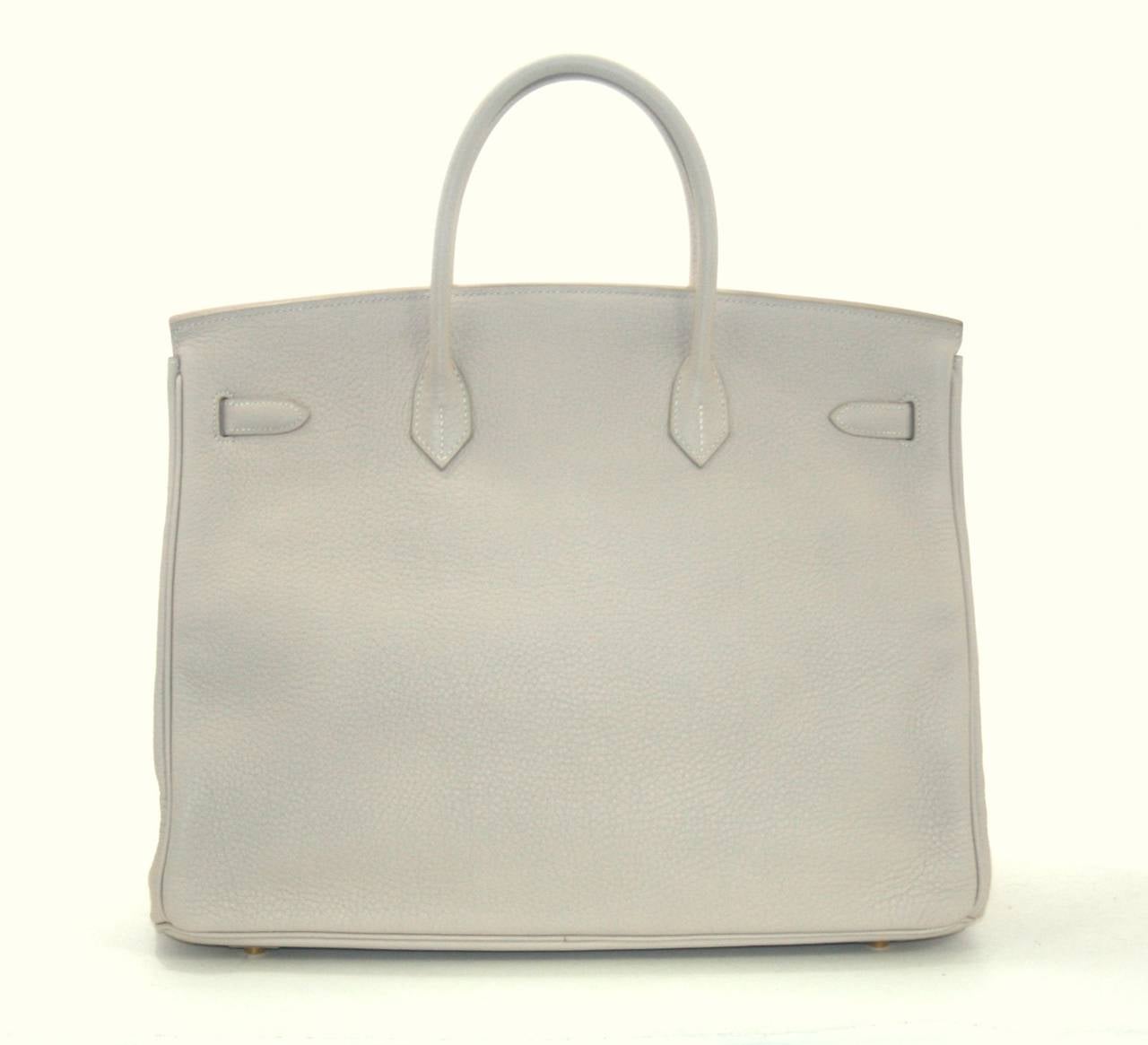 Nearly pristine Hermes Birkin in Poudre Togo Leather, 40 cm size. Protective plastic  intact on all the hardware except the feet and toggle; carried once.     Crafted by hand and considered by many as the epitome of luxury items, Birkins are