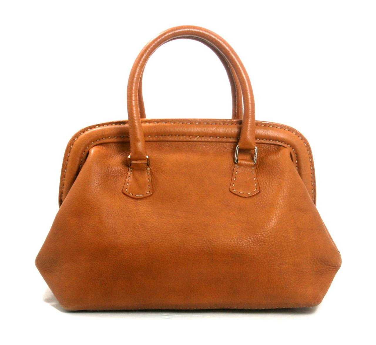 In very good condition, this Fendi Cognac Selleria Leather Doctor Bag is an iconic silhouette. There is light wear around the bottom edges and some minor white mars on the exterior.  The interior is generally clean, though there is an ink mark on