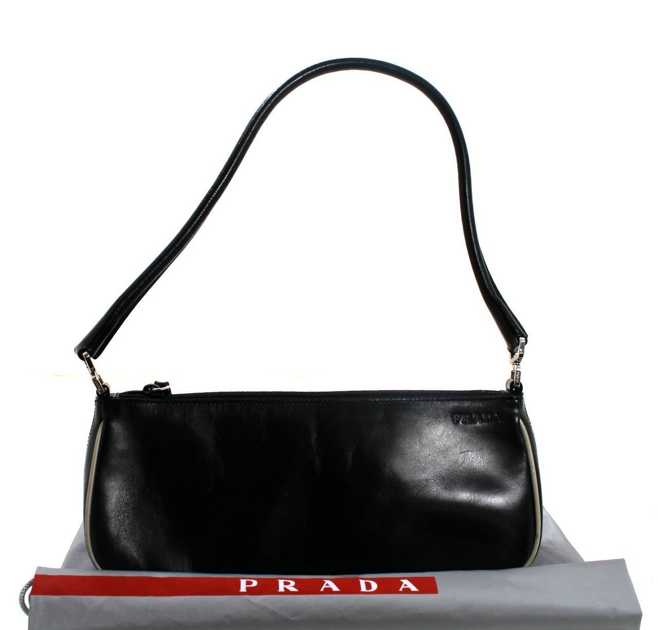 A fantastic find for a savvy shopper, this Black Leather Pochette from Prada is in very good condition.  The exterior is excellent with the signs of wear mainly on the corner piping. The interior is mint. Simply designed, it easily transitions to