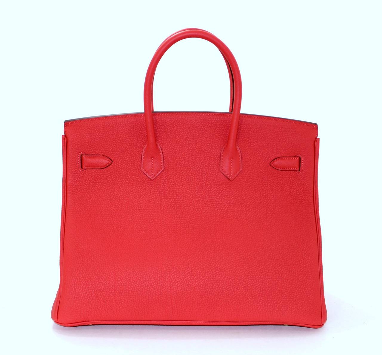 Pristine, store fresh condition (plastic on hardware) Hermès Birkin Bag in Rouge Pivoine Togo, 35 cm size.   Crafted by hand and considered by many as the epitome of luxury items, Birkins are extremely difficult to get. Scratch resistant and richly