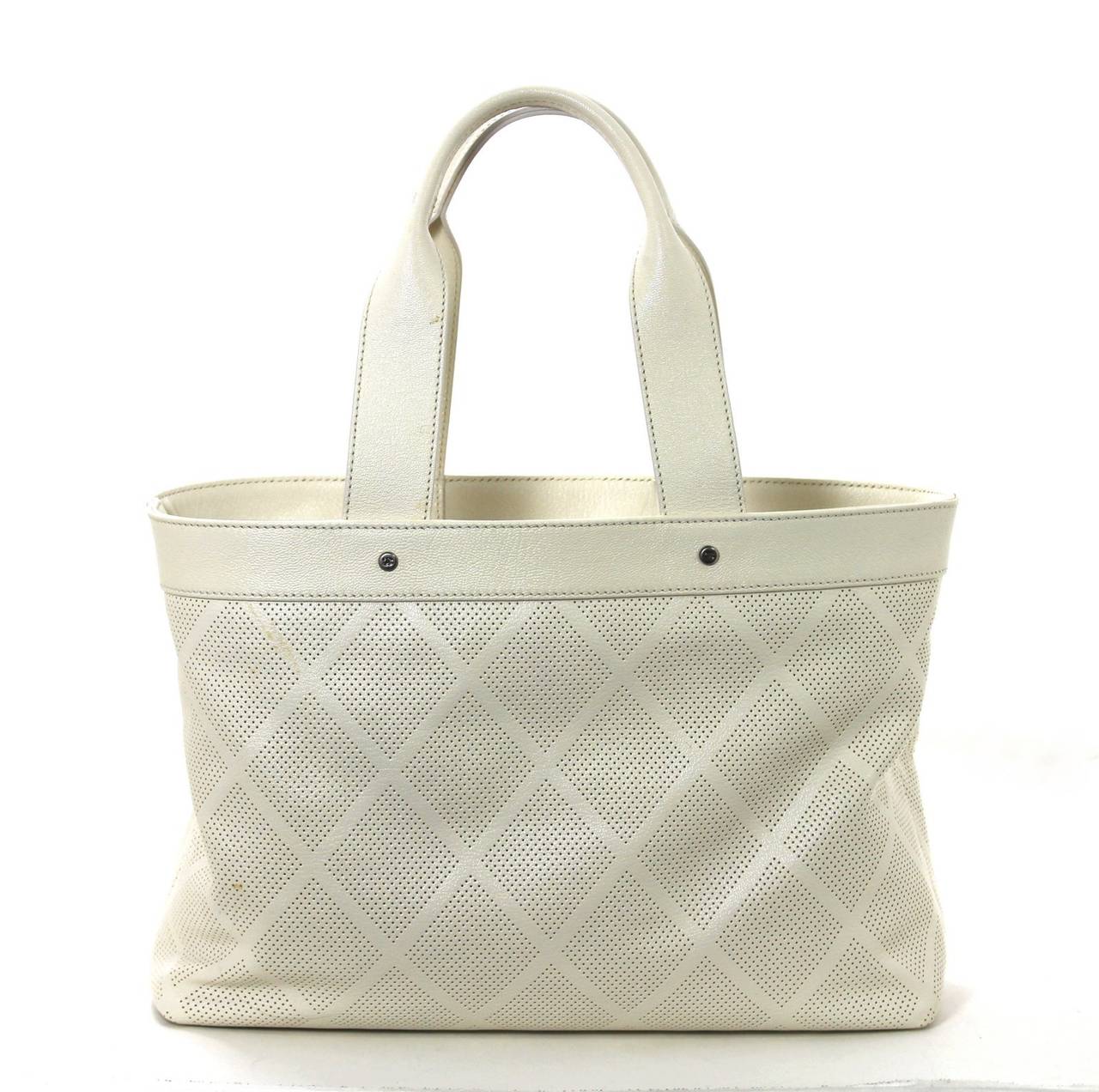 Just in time for summer, this Ivory Perforated Leather Tote Bag from Chanel is a fabulous find.  It is in better than excellent condition with only two tiny spots on the front that are not particularly noticeable; the interior is spotless.  The