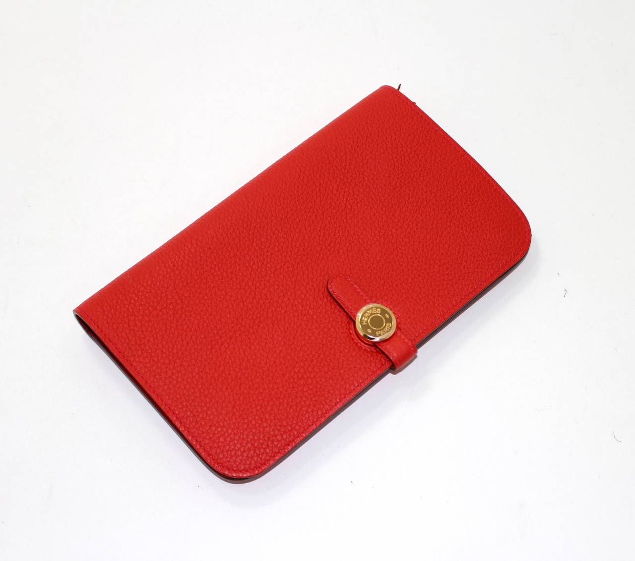 Hermès Vermillion Red Togo Leather Dogon Combined Wallet has never been carried.  It is in store fresh condition (plastic on hardware) and is accompanied by the original tissue and box.
Togo leather (grainy and scratch resistant calf hide)