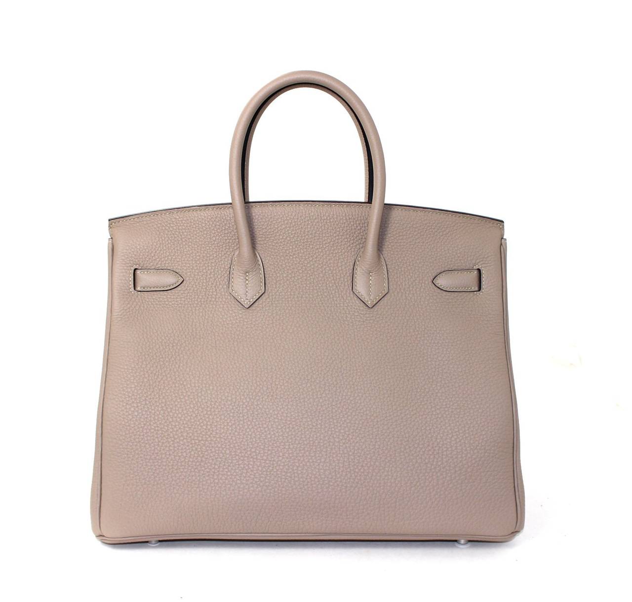 Pristine, store fresh condition (plastic on hardware) Hermès Birkin Bag in Gris Tourterelle Togo Leather with Palladium, 35 cm size.   Crafted by hand and considered by many as the epitome of luxury items, Birkins are extremely difficult to get.