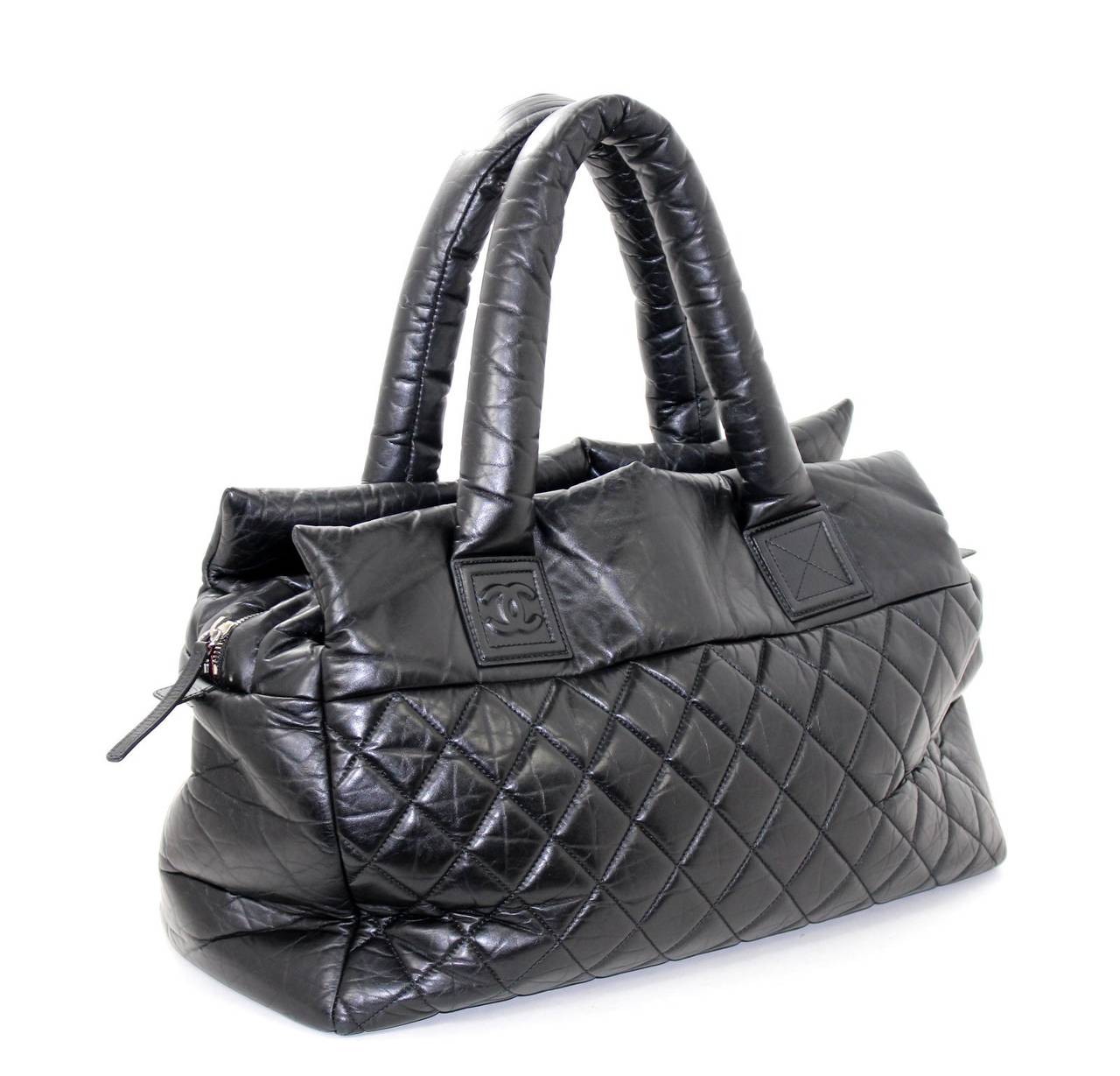 Chanel Black Lambskin Coco Cocoon XL Tote
Nearly pristine; barely ever carried. Estimated retail $3,600.00.

The Coco Cocoon Collection is sporty and chic; a relaxed departure from the structured classic pieces.  In all leather, this   XL version