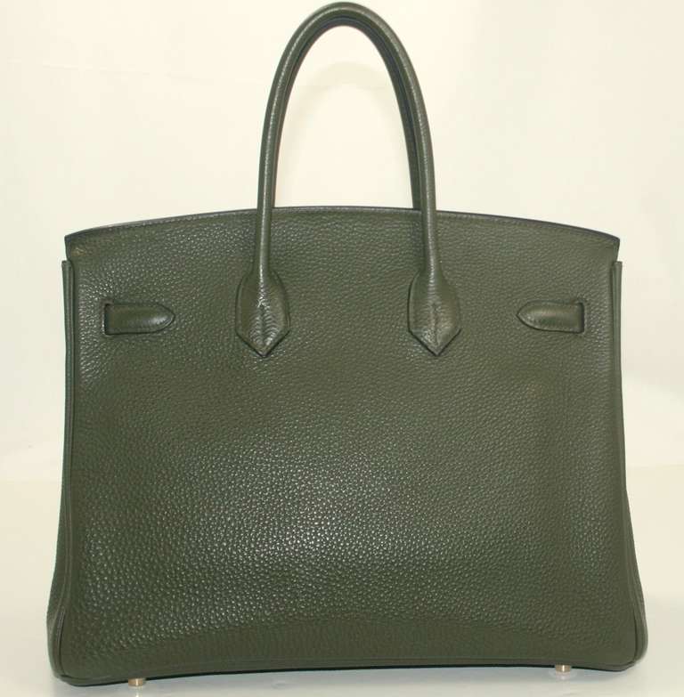 A fantastic find in overall mint condition, this Hermès Vert Olive Togo Birkin has only minimal signs of prior ownership. There are some very light scratches on the hardware and the handles have a slight sense of being gently carried but there is