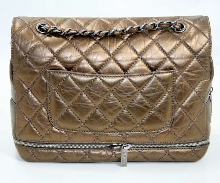 Chanel’s Dark Gold Distressed Leather Expandable Zip Flap Bag is a former store display from the Paris NY collection.  Never carried, it is in pristine condition.    Contemporary details combine with a classic design creating a perfect bag for year