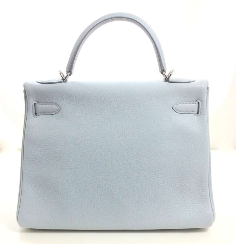 Stylishly refined, this Hermès Arctic Blue Evergrain Leather 32 cm Kelly has never been carried.  In fact, the protective plastic is still intact on the hardware.   Hermès bags are considered the ultimate luxury item worldwide.  Each piece is