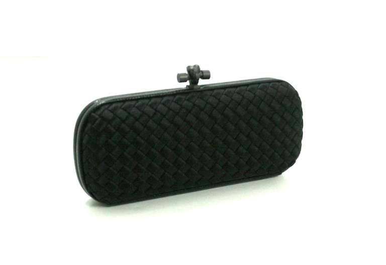 Bottega Veneta’s Black Satin Long Knot Clutch is a classic collectible in nearly pristine condition, perhaps carried once or twice.  The timeless style retails for over $1,750.00 with taxes and is an indispensable piece for any collection.   
 The