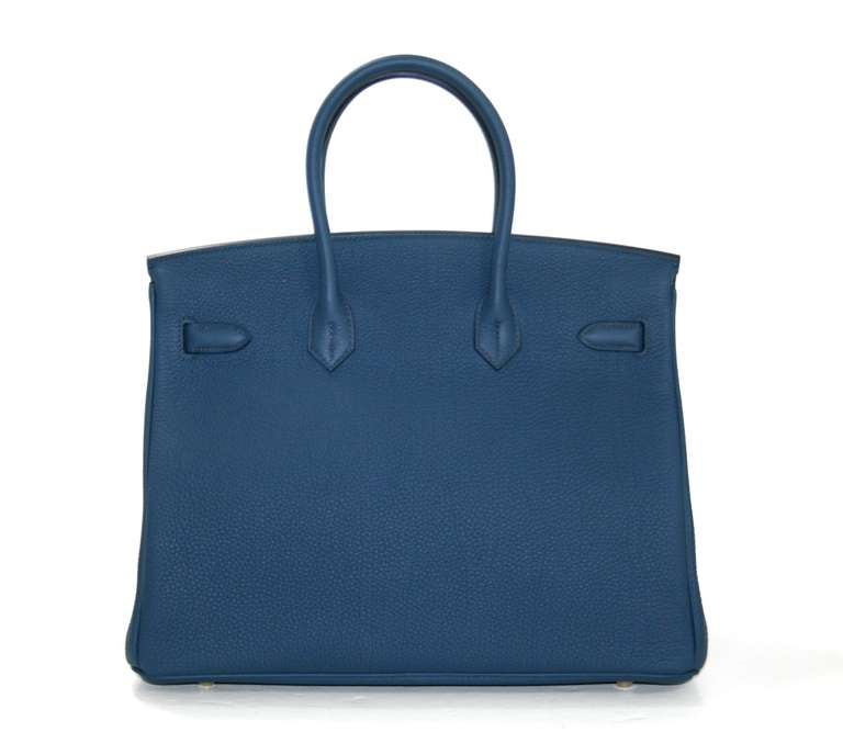 Very rare, this Hermès Bleu de Prusse Togo Leather Birkin is pristine and unworn.  The protective plastic remains intact on the hardware and it has been carefully stored.    Considered the ultimate luxury item the world over and hand stitched by