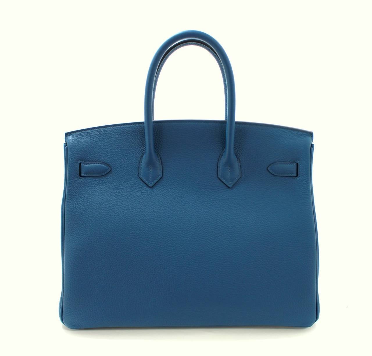 Pristine, store fresh condition (plastic on hardware) Hermès Birkin Bag in BLEU DE GALICE Togo Leather with Palladium, 35 cm size.   
Crafted by hand and considered by many as the epitome of luxury items, Birkins are in extremely high demand but