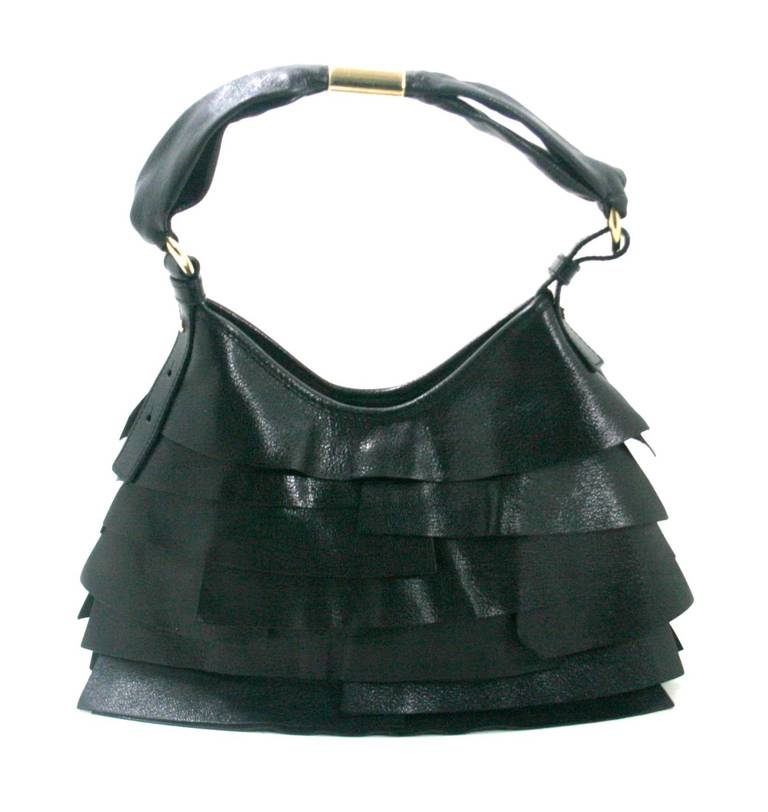 YSL’s Black Tiered Leather St. Tropez Bag designed by Tom Ford is a fantastic find in better than excellent condition.  There are some mild scratches on the hardware but the exterior layers are pristine as well as the suede lined interior.  
Black
