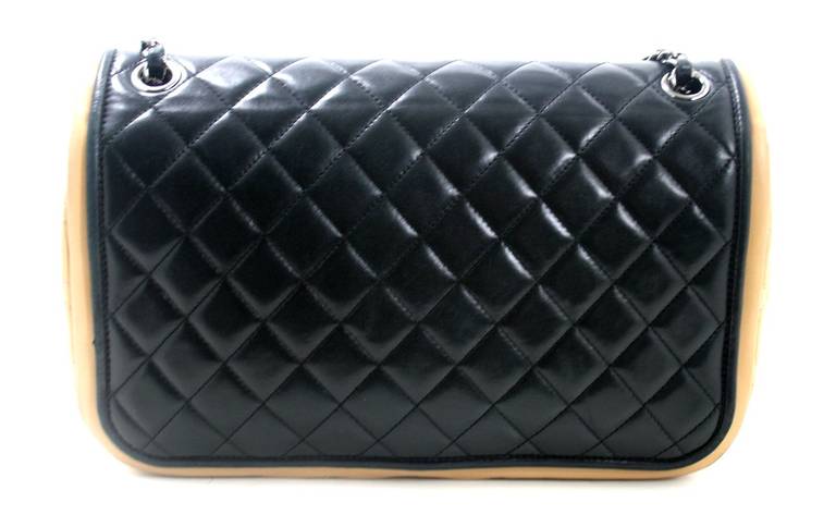 Chanel’s Black and Beige Leather Flap Bag is in excellent overall condition with subtle signs of prior ownership. There is light wear mainly on the corners and mild hardware scratching.  The classic black quilted style gets an update with a bold yet