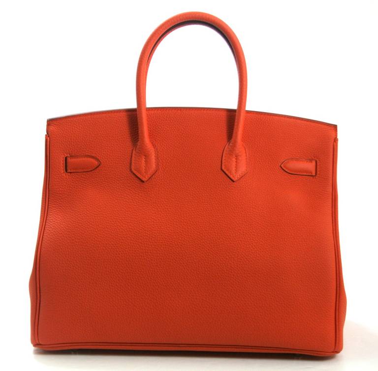 Pristine, new and never carried Hermès Birkin Bag in Orange Togo Leather, 35 cm size.   Crafted by hand and considered by many as the epitome of luxury items, Birkins are extremely difficult to get. Scratch resistant and beautifully textured,