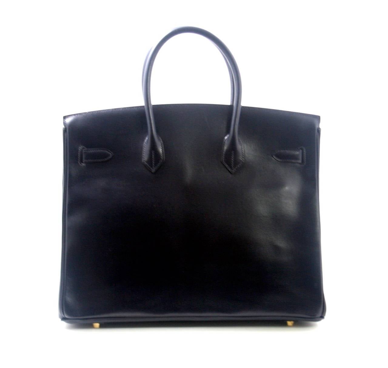 Truly mint, this Hermès 35 cm Indigo Box Calf Birkin is an incredible find.  There are a few slight surface scratches on some of the hardware, though the protective plastic is actually still intact on the center plaque. The corners have no signs of