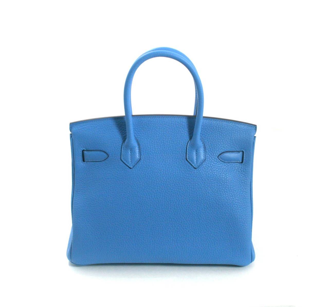 Never carried, this Bleu Paradis Clemence Leather 30 cm Birkin is in the newest shade of blue from Hermès.  It has been carefully stored with the protective felt and is absolutely immaculate.     Considered the ultimate luxury item the world over