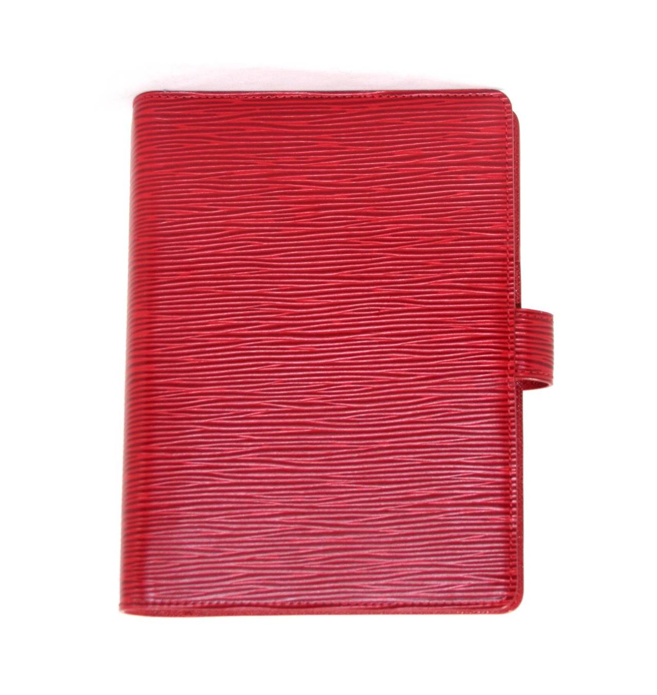 Louis Vuitton’s Red Epi Leather Agenda is in as new condition, appearing never carried.  A beautiful gift, this LV may be used as an address book, journal or date planner. Louis Vuitton currently has a comparable item retailing for over $860.00 with