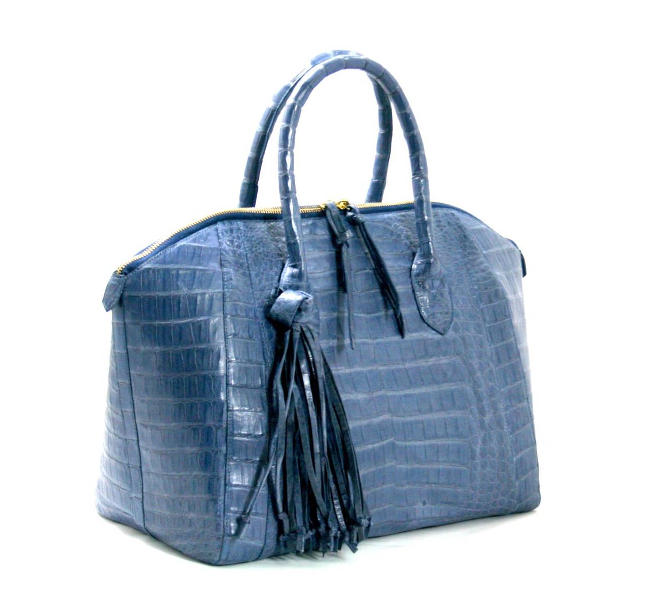 This Periwinkle Crocodile Domed Tassel Satchel from Nancy Gonzalez is a store return in pristine condition, appearing never carried.  Stunning, this cool periwinkle blue adds a sophisticated taste of color to any ensemble.  Currently retailing for