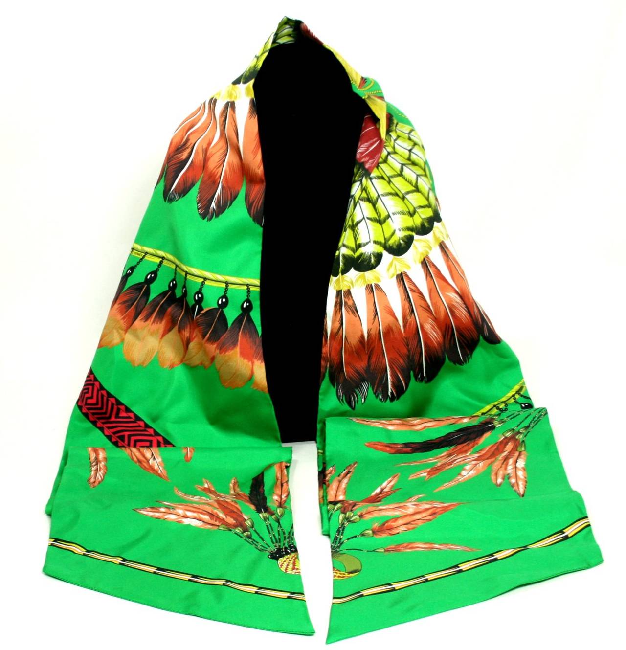Never worn, this Hermès Vert Brazil Maxi Twilly is both stunning and collectible.  The possibilities are endless for this flowing silk scarf in vivid shades of vert, brun and absinthe. 

 The Brazil design features a vibrant green background with