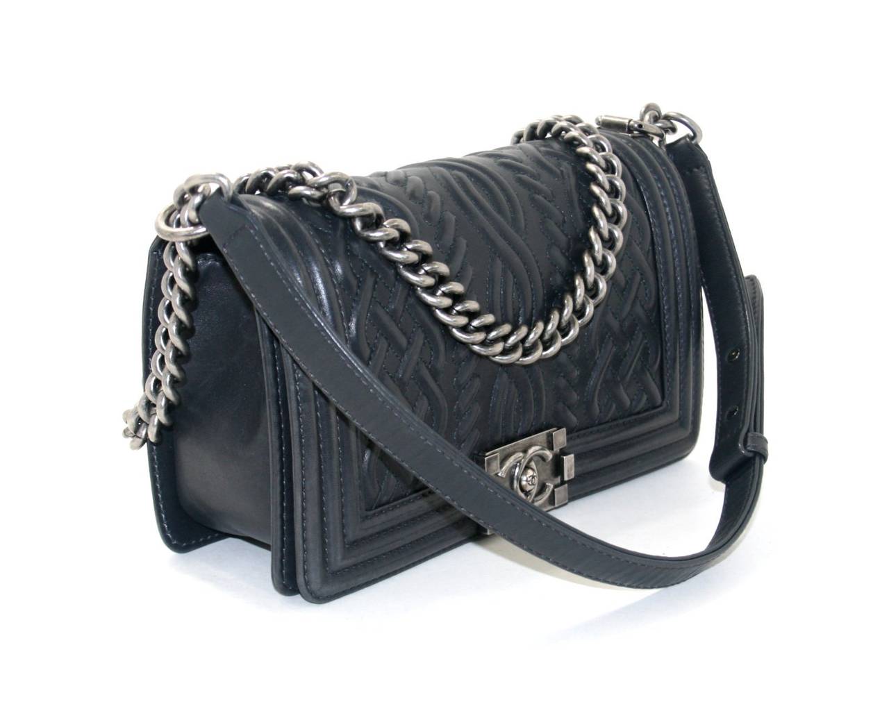 Chanel’s Charcoal Leather Medium Celtic Boy Bag is a rare piece in mint condition from the Pre Fall 2013 collection. It features a raised Celtic cabled knit design on the Boy Bag silhouette.  A very unique style, it is a must have for collectors
