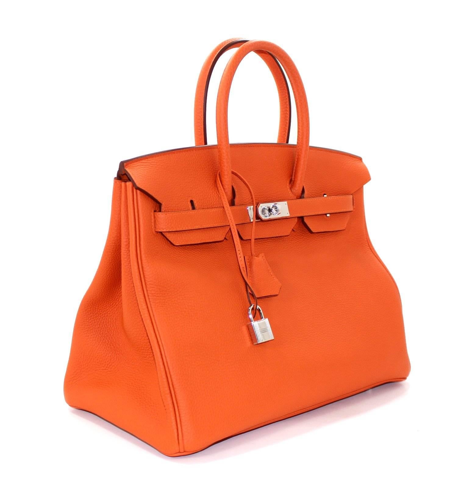 Hermès ORANGE 35 cm Birkin Bag is PRISTINE.  Store fresh (plastic on hardware) with padlock, keys, clochette, protective felt, raincoat, dust bags and Hermès box with tissue.  
World recognized as the penultimate luxury item, wait lists of a year