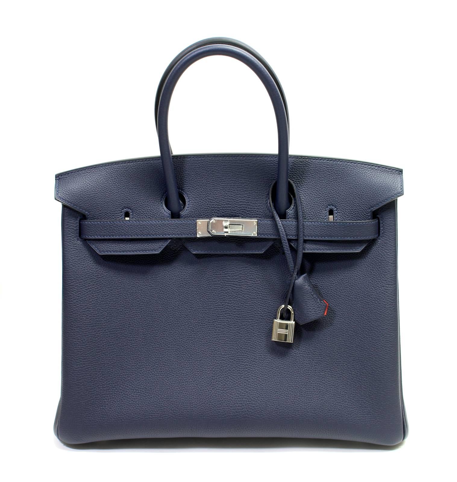 Hermès Togo Verso Birkin Bag- Bleu Nuit and Orange Poppy 35 cm
 Store Fresh; Pristine with plastic intact on all hardware.  
Verso is the newest version of the Birkin released in 2017.  Two tone; a contrasting interior color adds a unique twist to