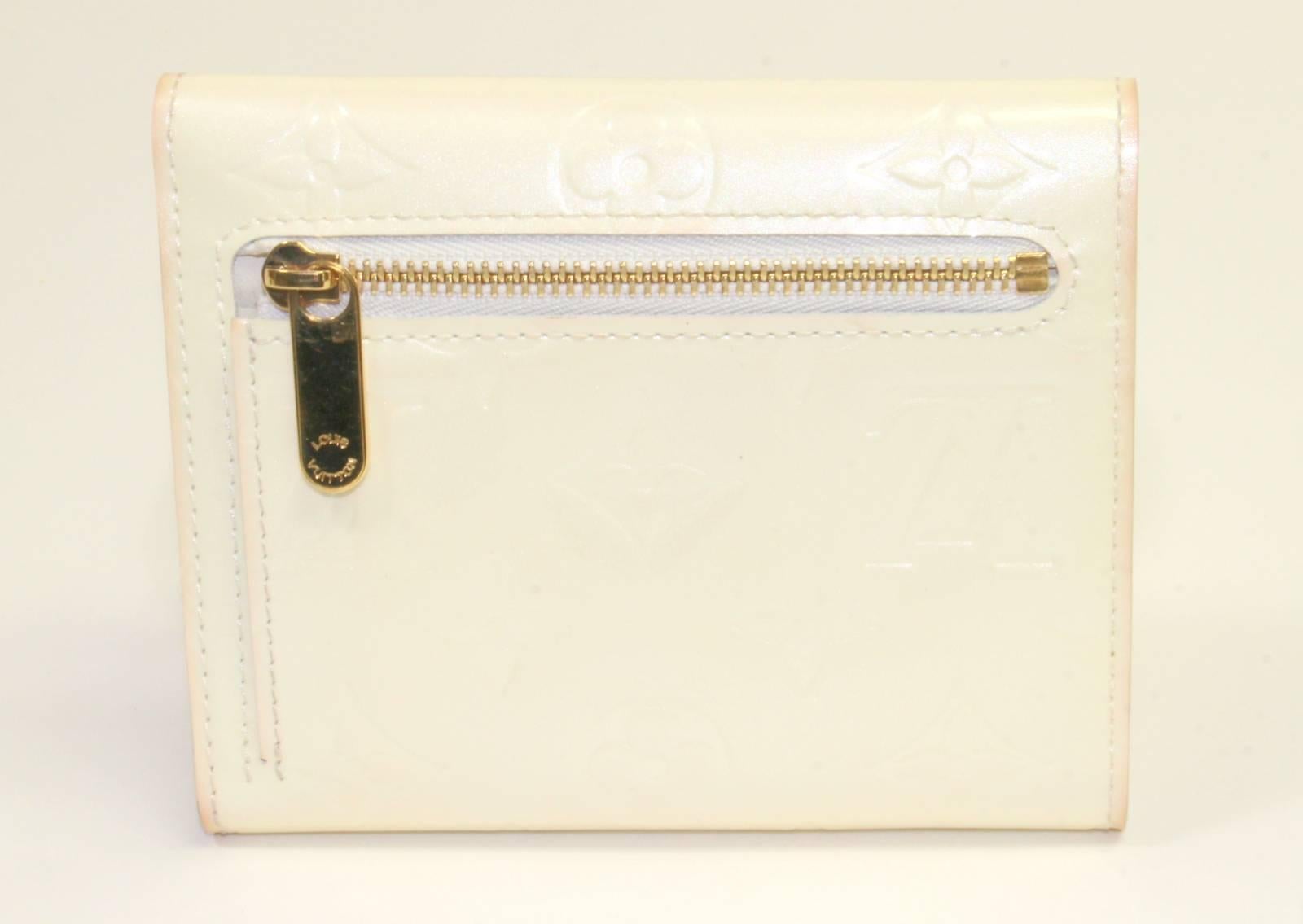 Louis Vuitton Ivory Monogram Vernis Koala Wallet- VERY GOOD; Retail $750.00.
 The trifold style is very practical; it easily organizes all the necessary cards and currency without taking up a large amount of space.
Ivory monogram Vernis patent