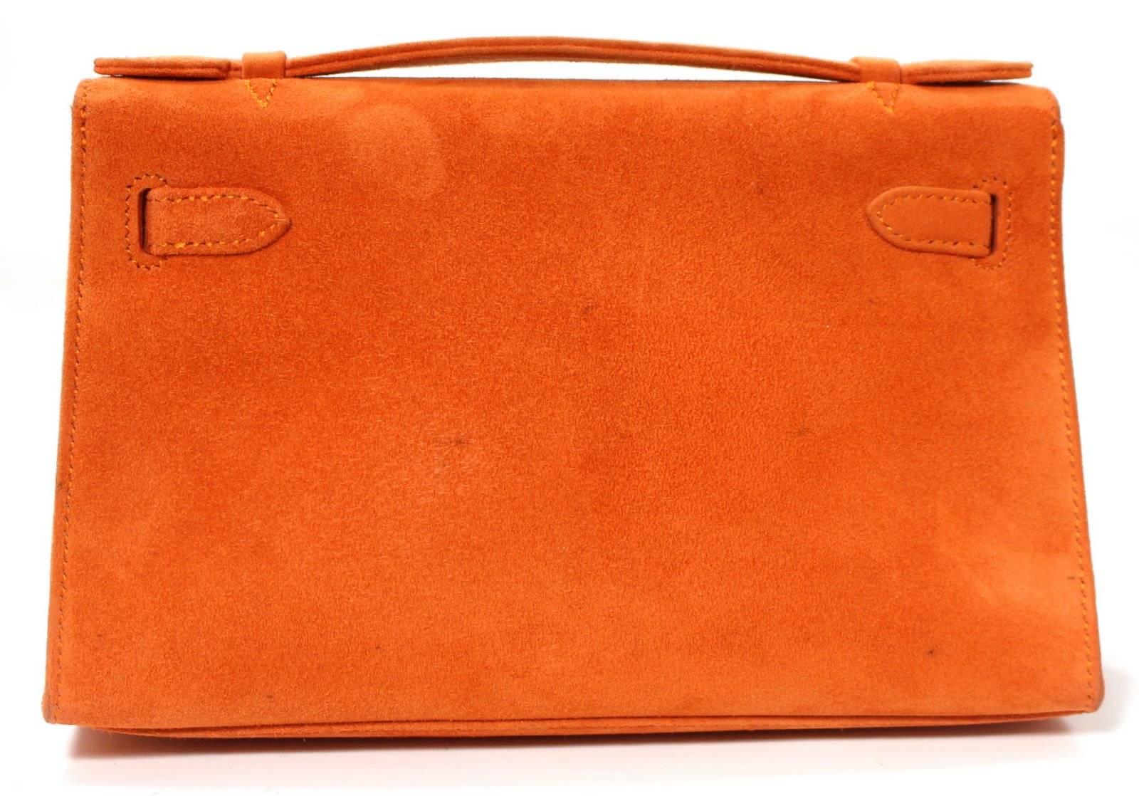 Hermès Orange Suede Kelly Pochette- EXCELLENT condition, approximate estimated current value $10,000.00.
Palladium hardware still has the protective plastic intact. There is mild corner wear and a few minor spots on the rear panel.    This is a