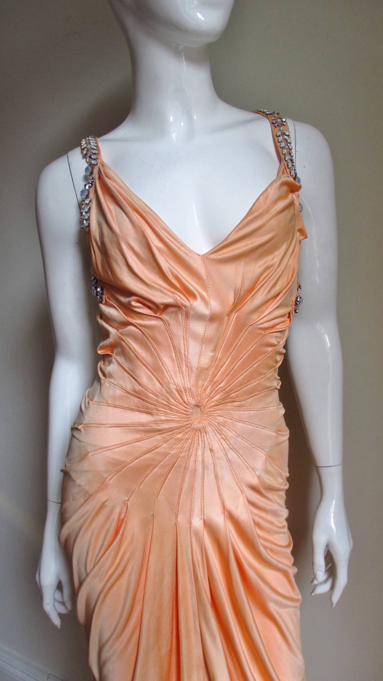 This is an amazing peach silk jersey gown from Gianni Versace.  It has gorgeous prong set rhinestones in flower and leave patterns along the shoulder straps which cross in the back and follow the armholes in the front.  There is a circular pattern