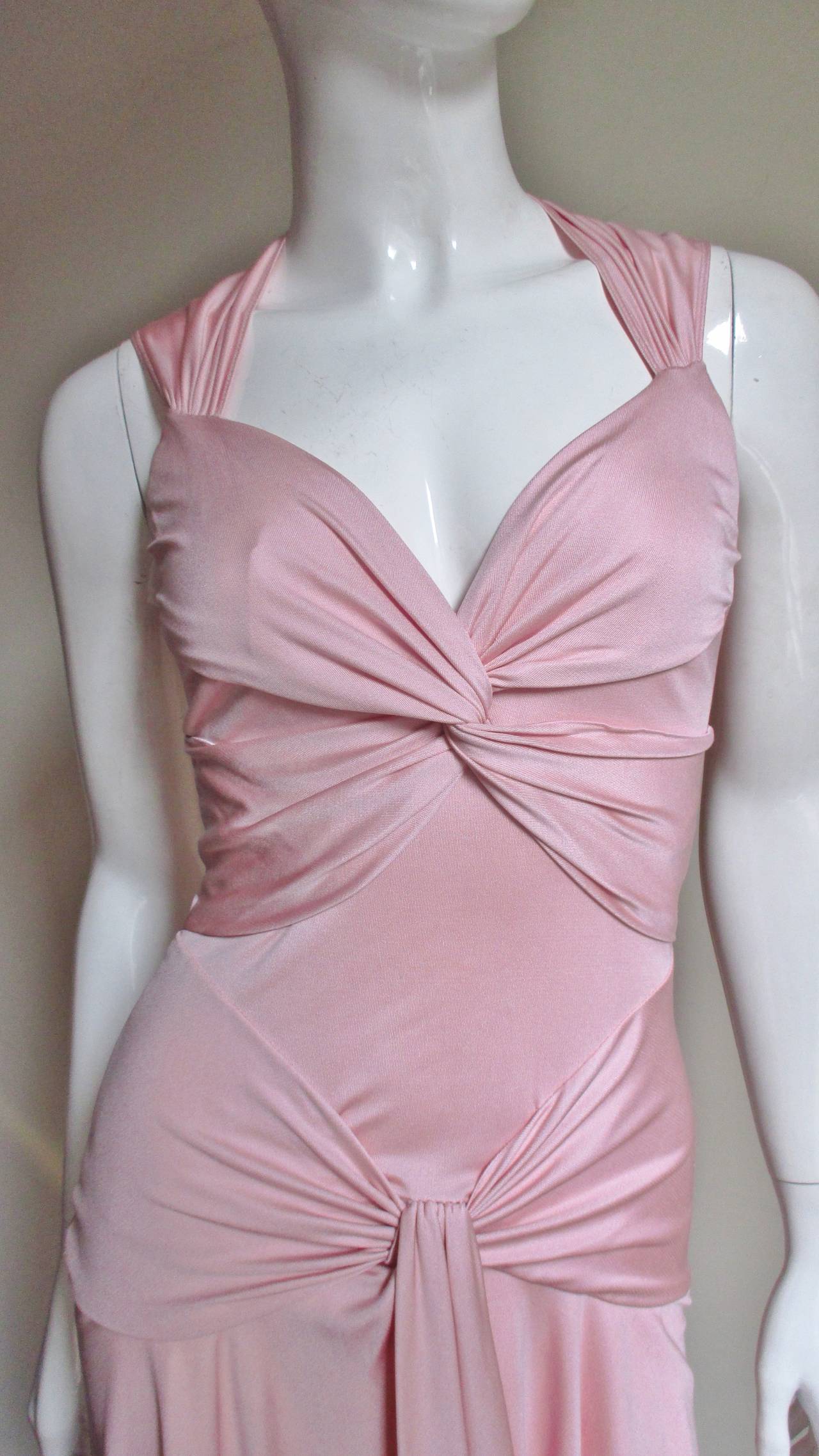 A great soft pink silk dress from Valentino.  It is sleeveless with a plunge neckline formed with gathered straps that cross the front over the bust and across the hips meeting at the center front forming a tie.  The skirt is full and graceful with